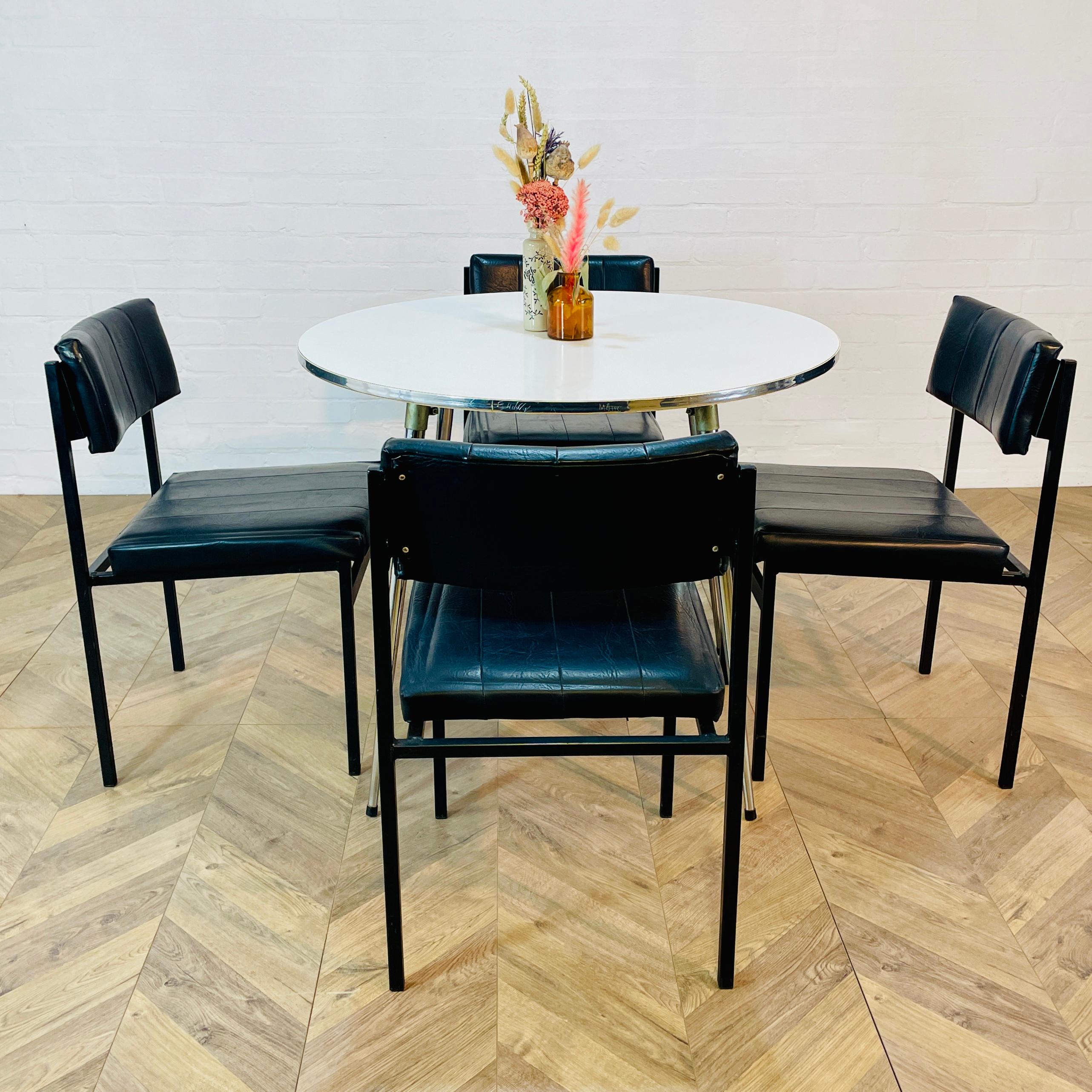 A Set of 4 Mid Century Black Dining Chairs, Designed by Godfrey Syrett, Circa 1960s.

The chairs, which have original black vinyl upholstery and black metal frames, all are in good condition, with only age related marks and scuffs to the frames and