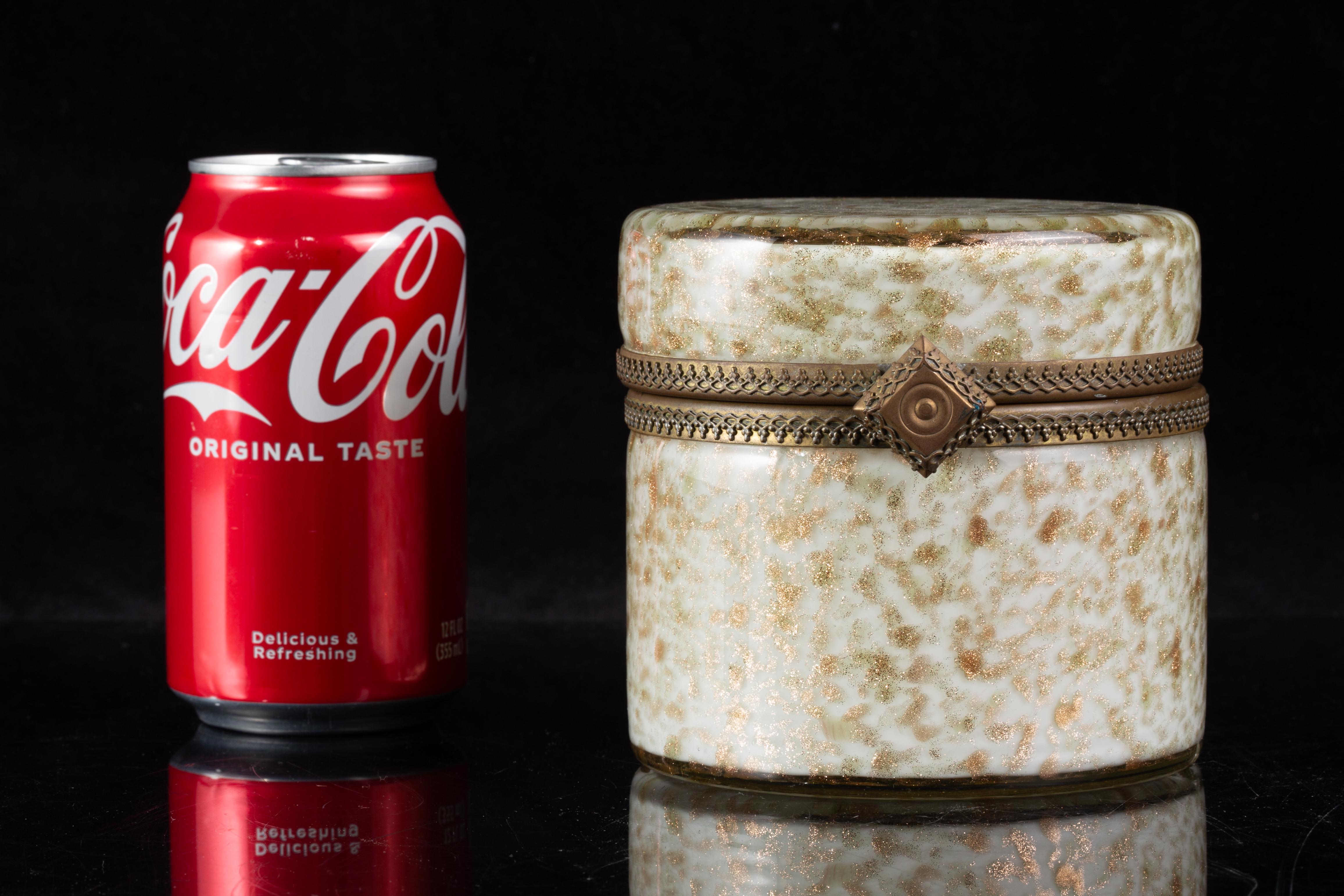 Boîte à bijoux cylindrique à charnières en verre Murano doré et aventurine du milieu du siècle dernier

Cette boîte en verre d'art de Murano est formée d'une forme cylindrique avec une base plate et un couvercle arrondi, réunis par une monture à