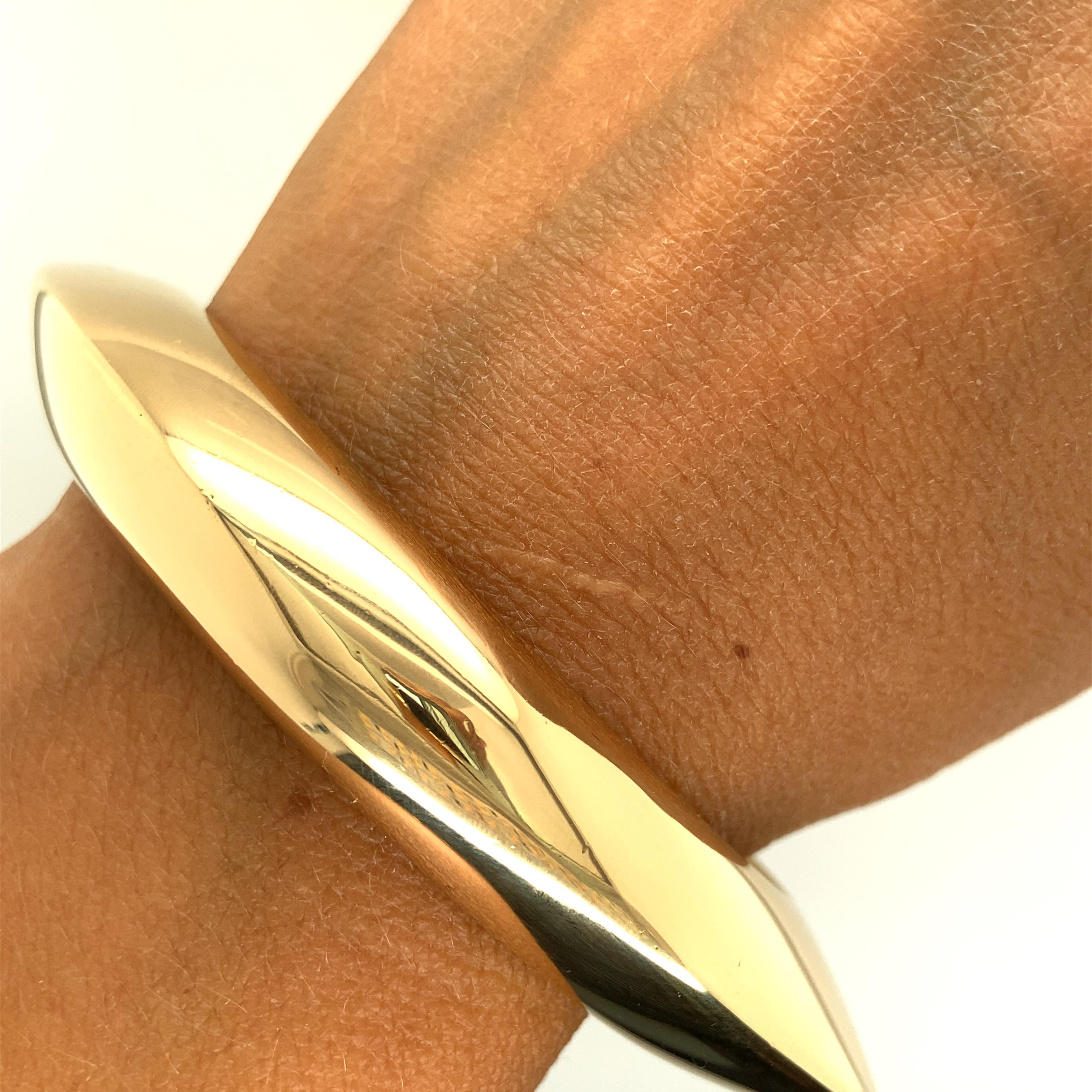 One 18 karat yellow gold (stamped NJ GEORG JENSEN 18K 750)  bangle bracelet by Nanna Ditzel for Georg Jensen. The bracelet measures 2.25 inches in diameter.  Circa 1956