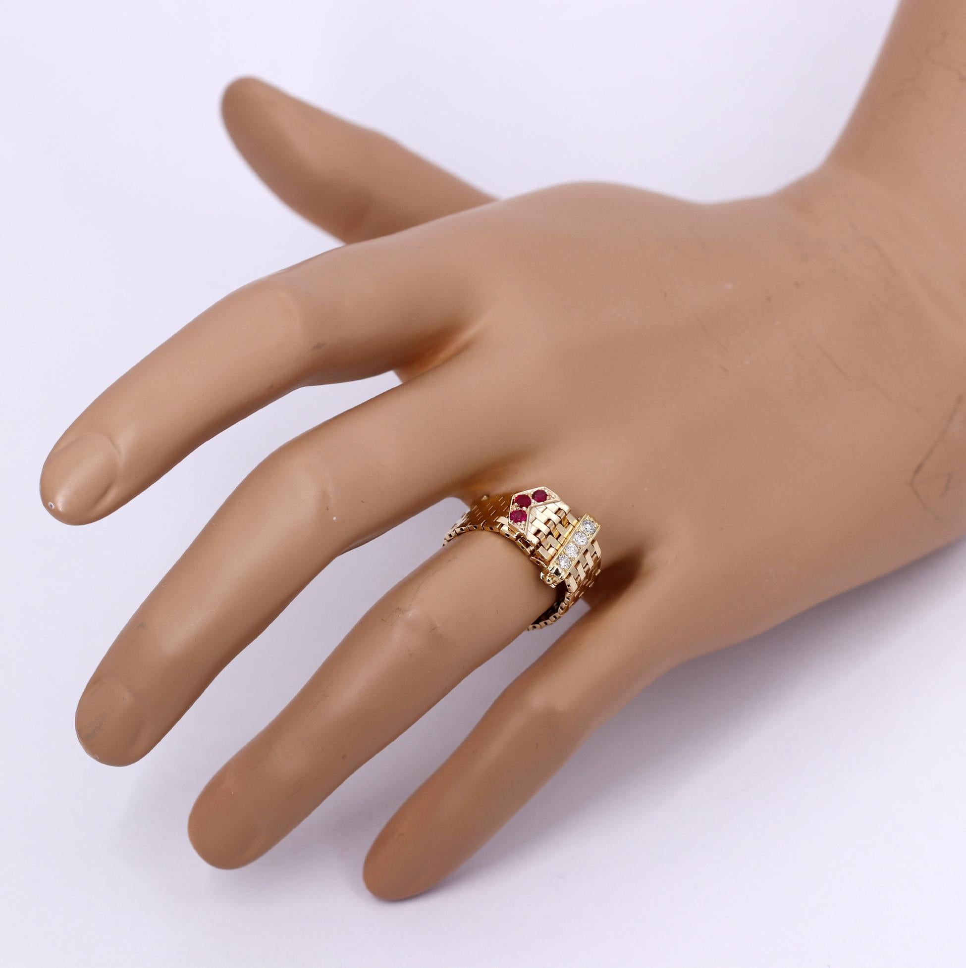 A 14K yellow gold ring measuring 3/8 inch wide, with a buckle design, and set with diamonds, rubies. The buckle is set with 4 round brilliant cut diamonds weighing 0.16 carats, and the tongue is set with 3 rubies weighing a total of 0.18 carats.