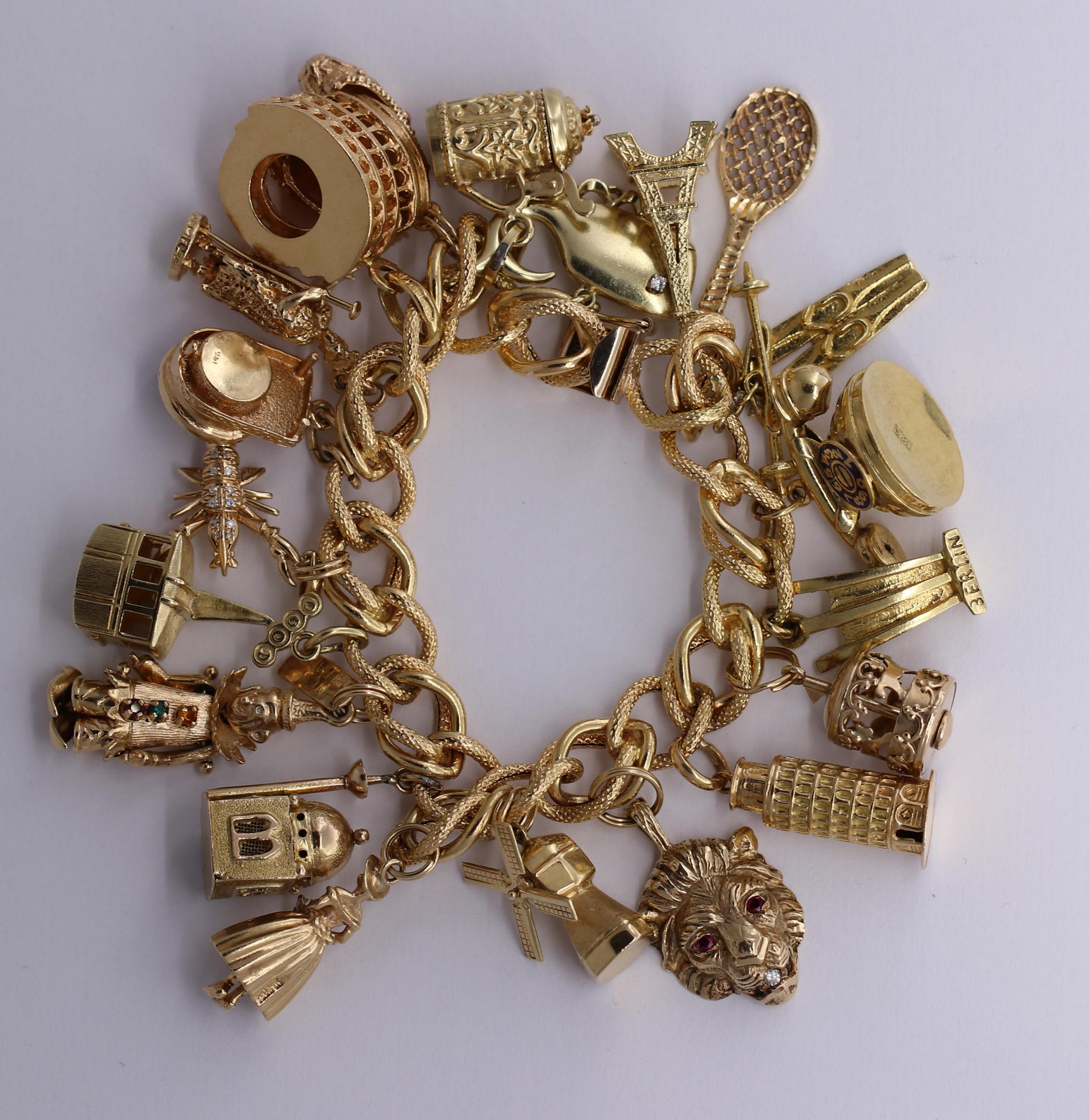 A festive charm bracelet on a 14K yellow gold spiral links with interlocking Florentine finished and high polished links. There are three, 18K charms: the tower of Pisa, The Colosseum, and a rotary phone with enameled dial. There is also a German