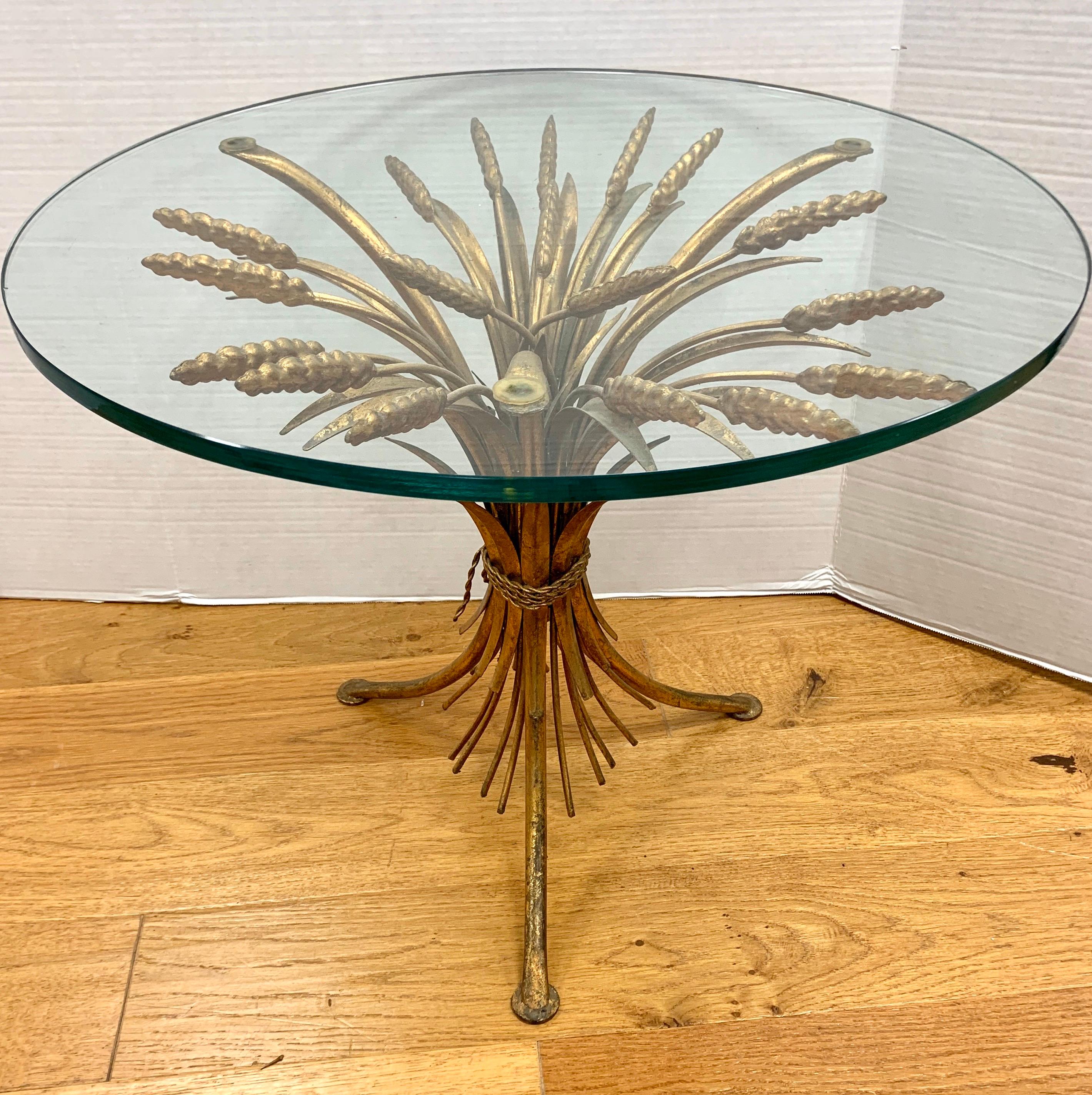 Iconic midcentury wheat sheaf table with sheaf base which is made of gilt metal and a round glass top.
Made in France, circa 1960s-1970s.