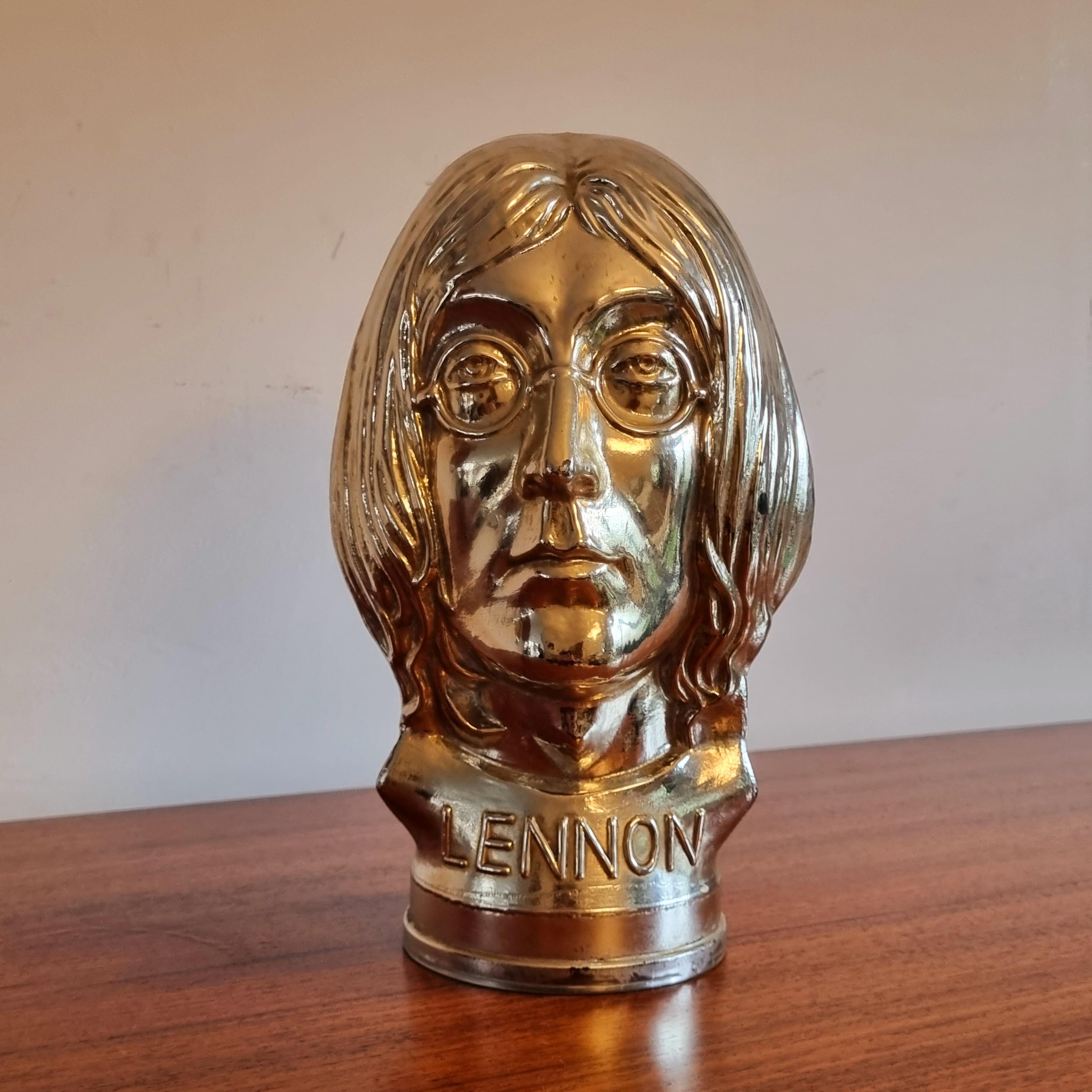 A cool John Lennon glass head
that was made in England in 1969.
This is a head made of glass of John Lennon from The Beatles. On the bottom front, you can read LENNON and on the bottom back, THE BEATLES.It's such a piece of art: every detail of