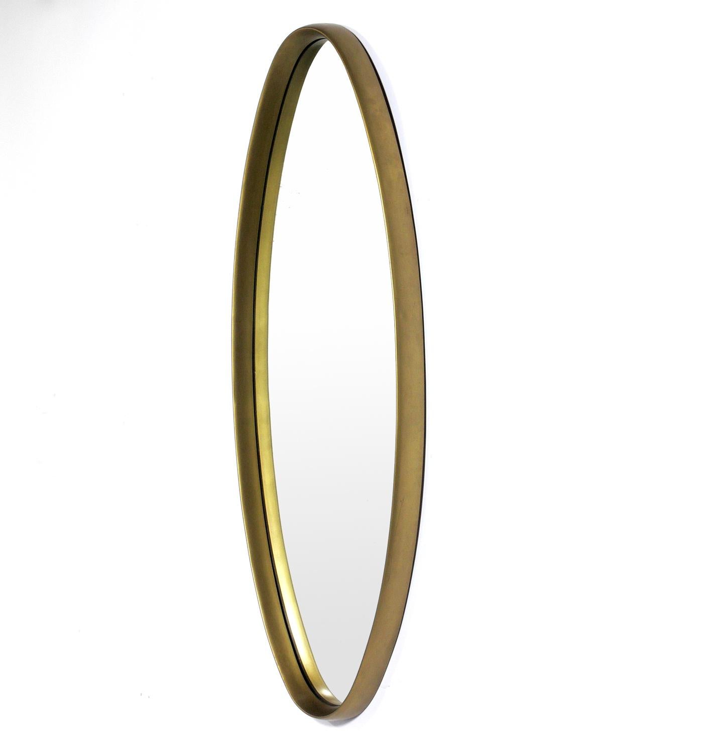 Midcentury oval gold mirror, American, circa 1960s. This mirror has a sculptural form and would fit seamlessly into a wide range of interiors, from traditional to ultra modern.