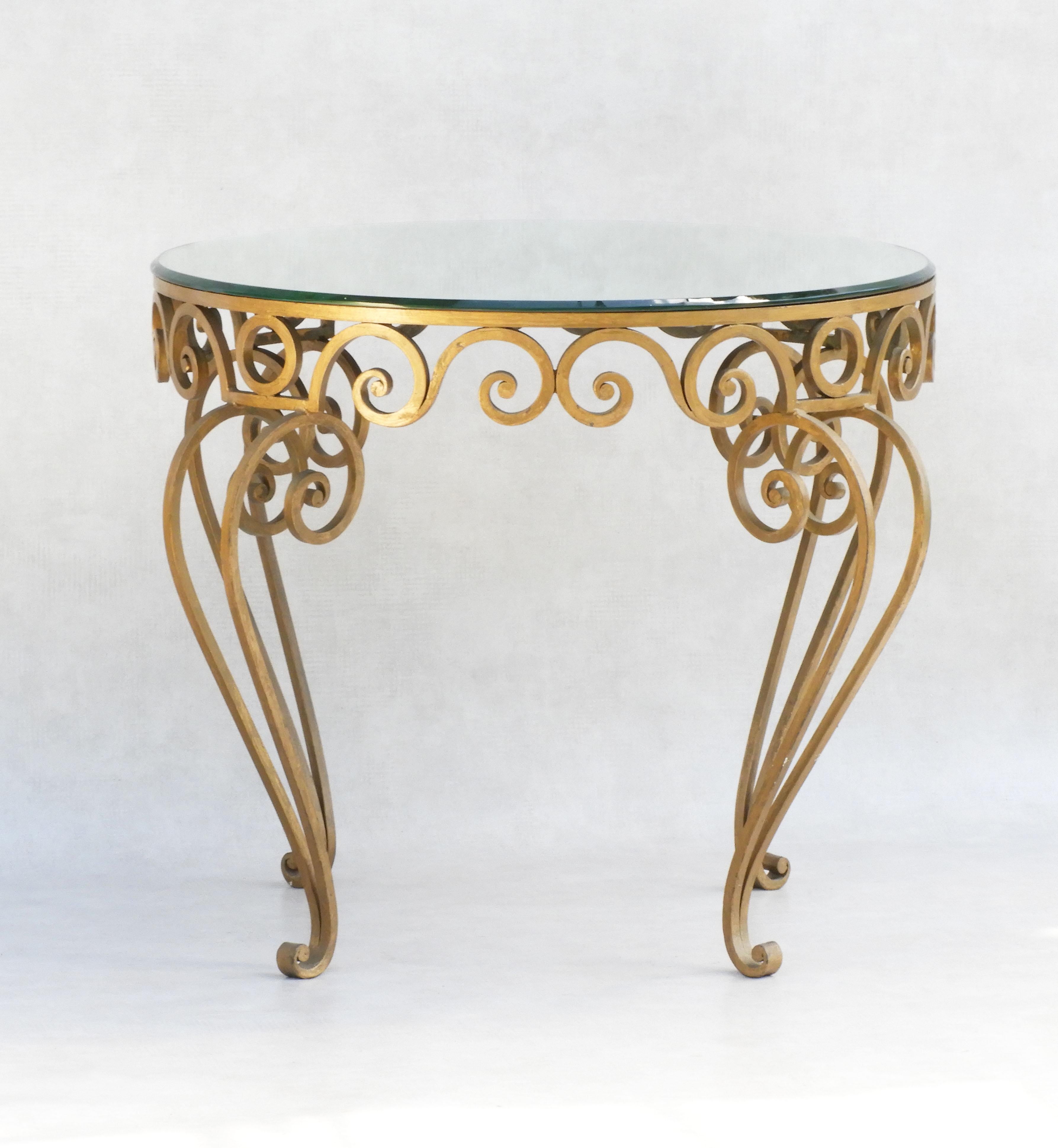 Vintage French Hollywood Regency Style coffee table circa 1950.
Stunning gold wrought iron mirror top occasional table. Hand forged wrought iron frame with original round bevelled mirror top.
In great condition with good patina, no losses to glass