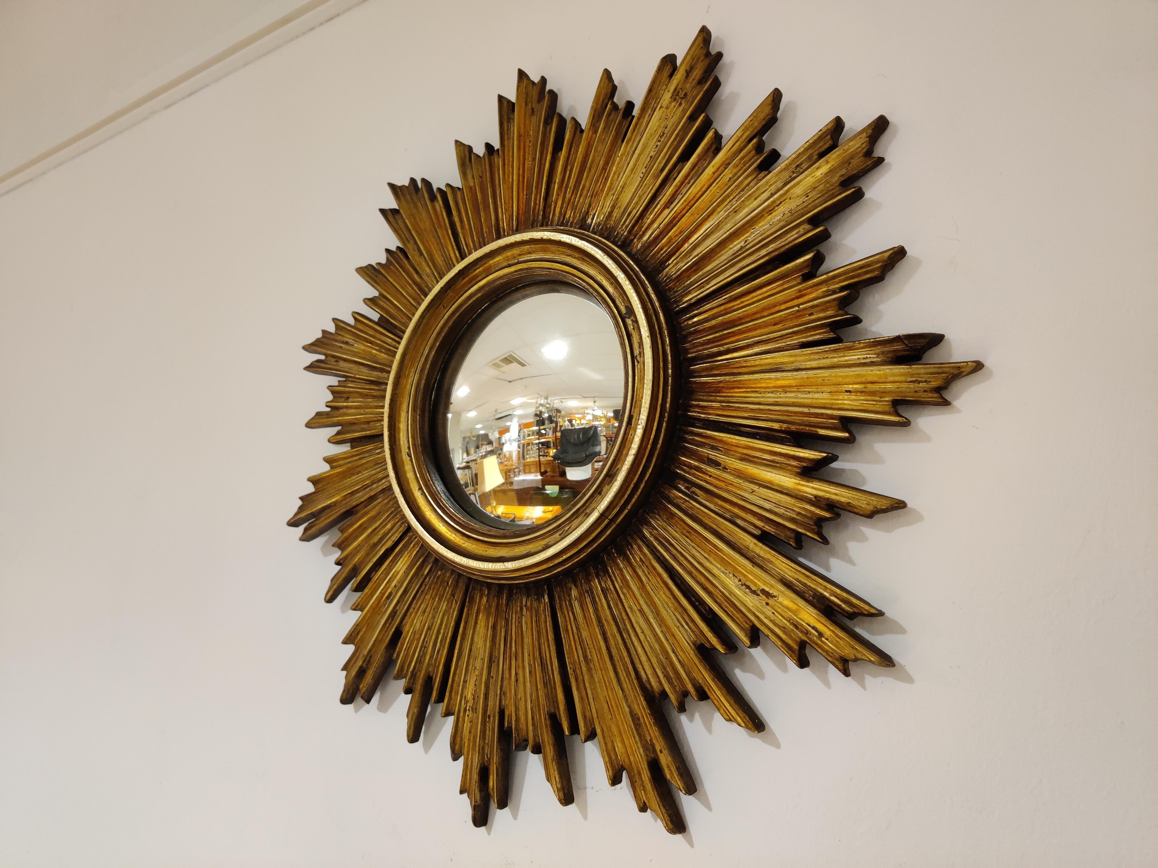 Gilded resin sunburst mirror with convex mirror glass.

The golden mirror is in a very good condition.

Beautiful eye catching mirror,

1960s, Belgium

Good condition.

Dimensions:

Diameter: 46cm/18.11