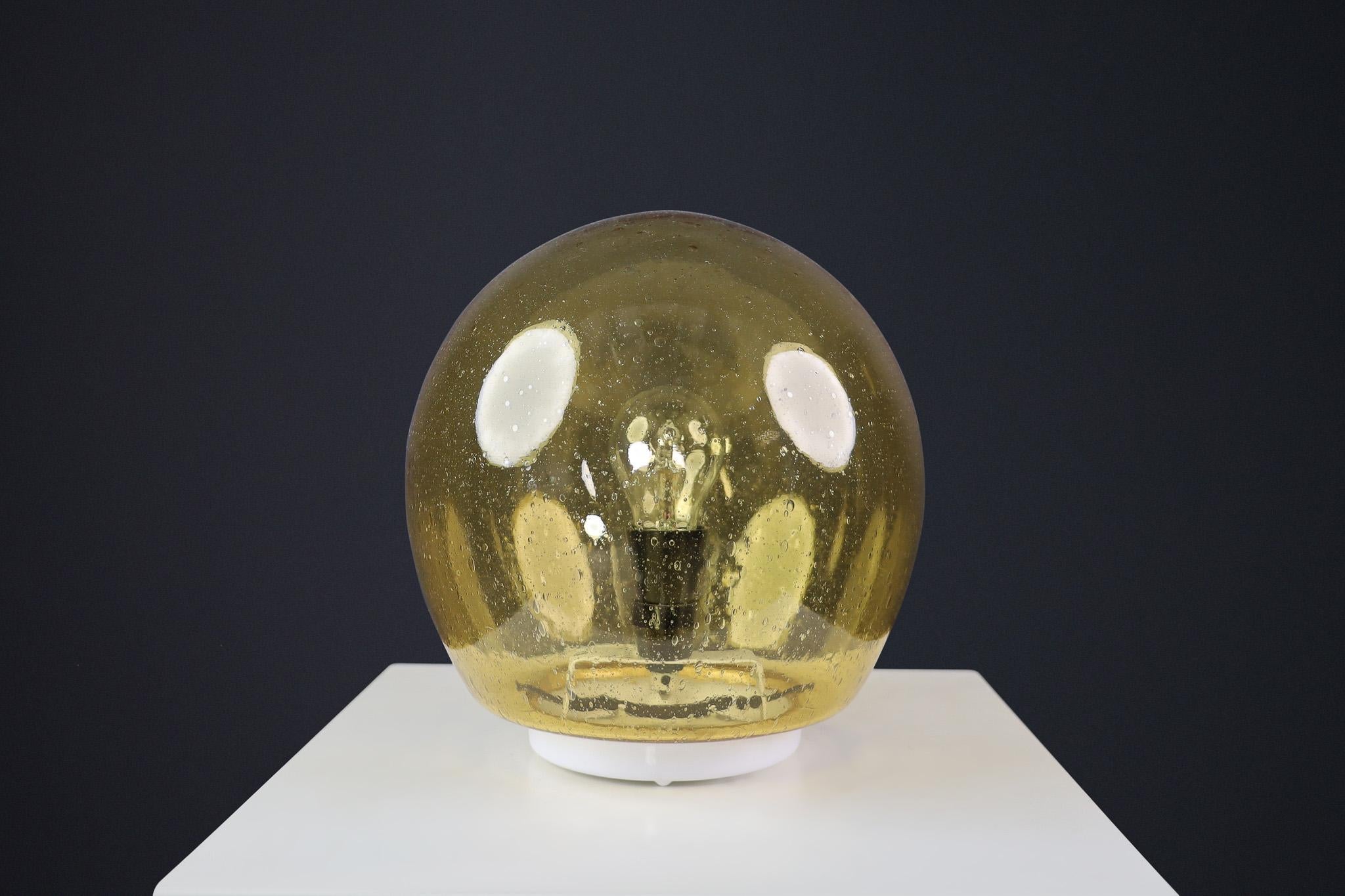 Mid-Century Murano Glass Desk/Table Lamp, Italy 1970s

This 1970s table lamp is crafted from Murano glass in Italy. Its globe-shaped shade and distinct patterns are characteristic of Murano glass from that era. This beautiful piece seamlessly