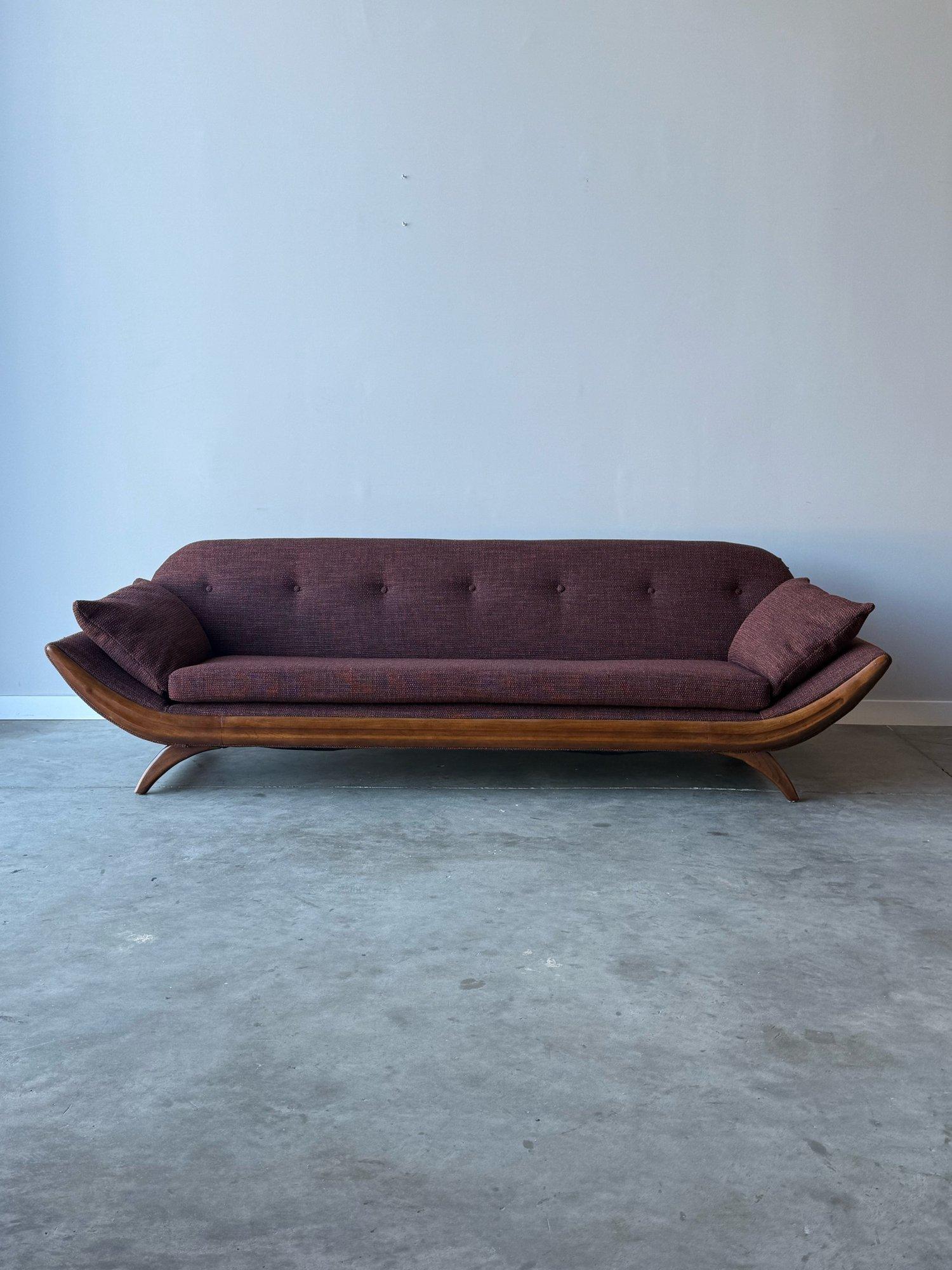 Mid-century gondola sofa in the style of Adrian Pearsall. This sofa is perfectly retro and modern wrapped in one. The walnut frame is curved, hence the name gondola. The curvature follows suit on the back of the sofa and gives this piece an oval