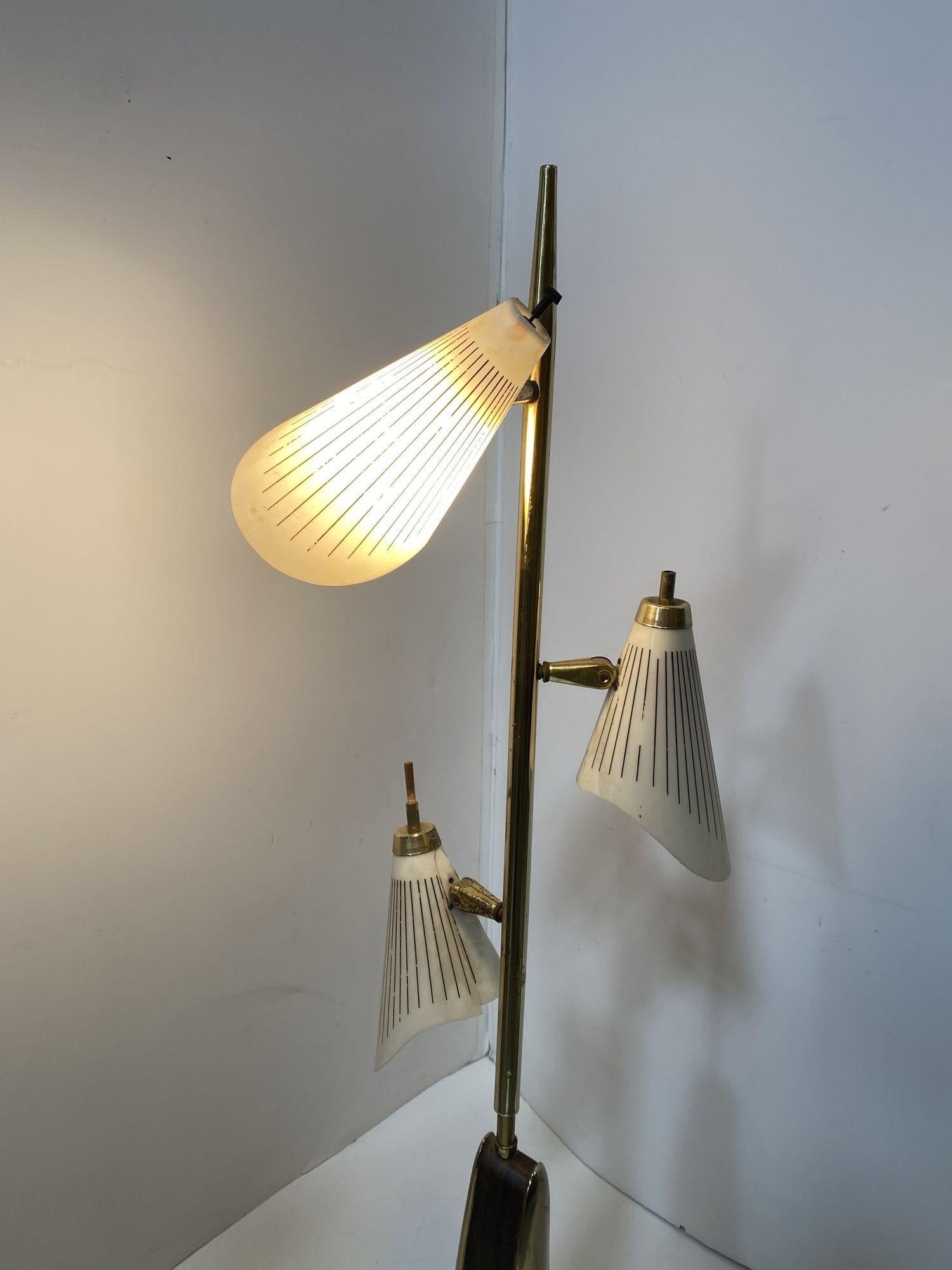 A unique two-tone polished brass Mid-century floor lamp featuring a casted sculptural base and fiberglass shades. Drawing from natural forms like driftwood with Googie styled shades this lamp features a unique look that fits in any Mid-century