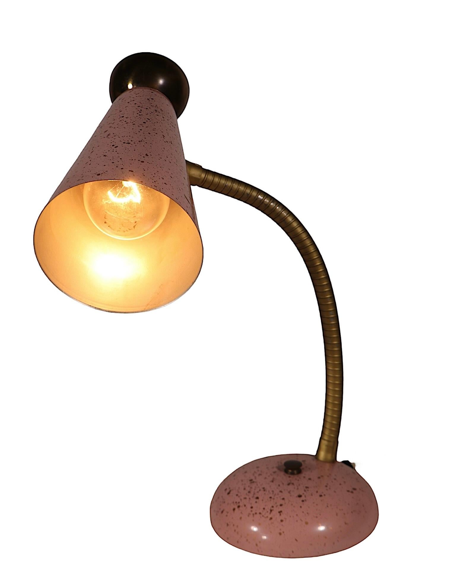 Classic Mid Century 1950's gooseneck desk lamp in original  pink and gold spatterware paint finish. The lamp features a cone form shade with decorative brass cup top, on a brass colored coil flex arm, on a dome form base. Hard to find period 1950's