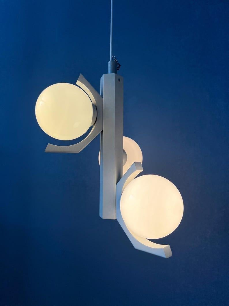 Gray bony design space age pendant lamp with three opaline glass shades. The frame is made out of white an has a gray lacquer. The milk glass shades are white. The lamp requires three E14 lightbulbs.

Additional information:
Materials: Glass,