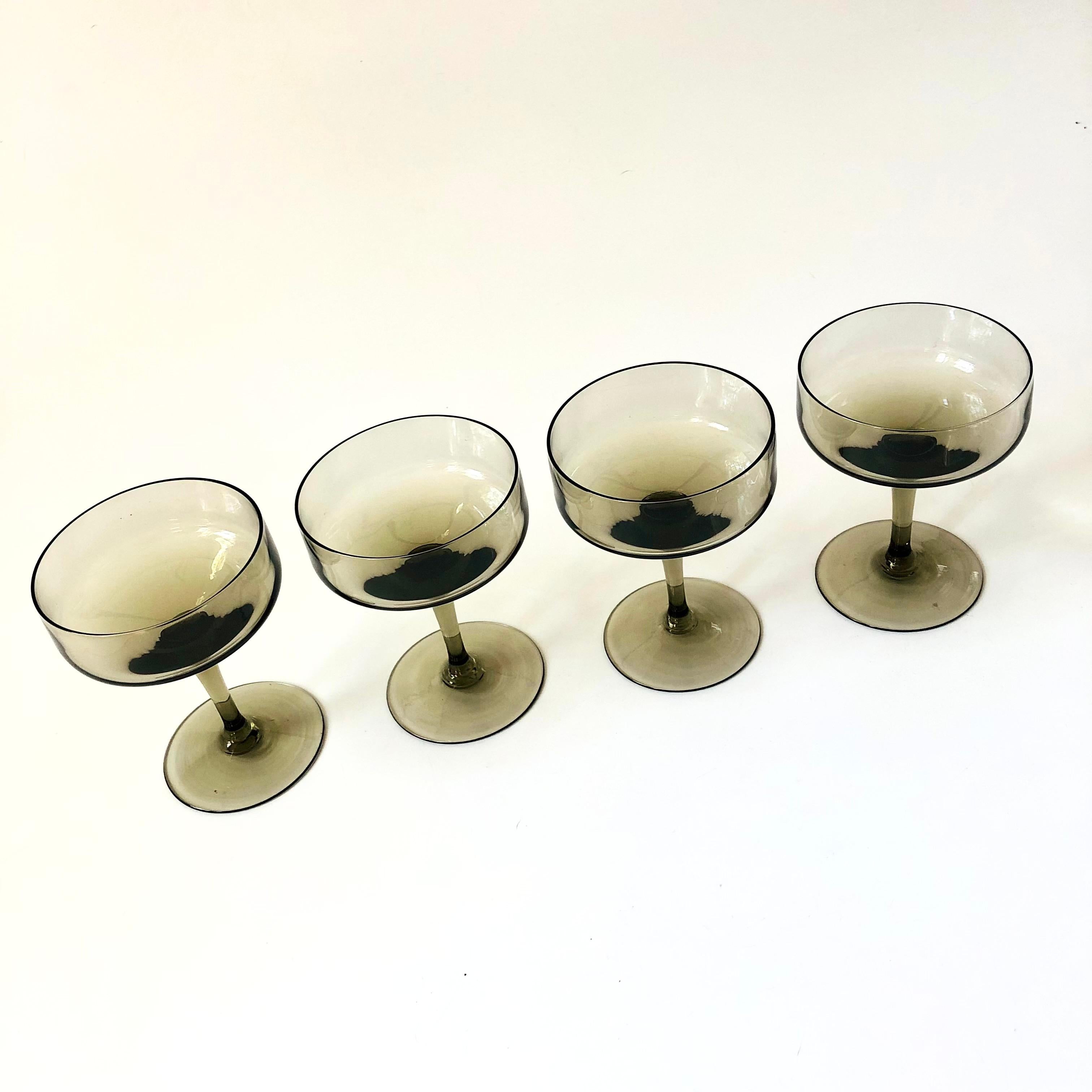 A set of 4 vintage coupe glasses in an elegant Mid Century shape. Each piece has been made in a lovely gray color. Perfect for champagne or wine.

