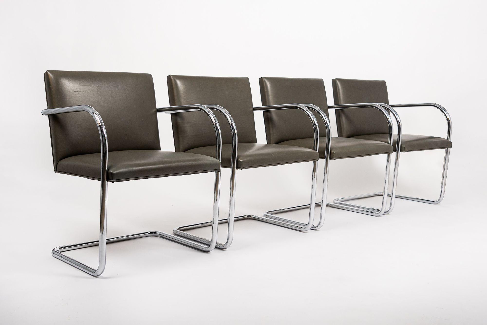 This set of eight mid century modern Brno arm chairs by Mies van der Rohe for Knoll were produced in 2002. These iconic Bauhaus modernist cantilever chairs originally designed by Ludwig Mies van der Rohe in 1930 feature clean lines and a simple