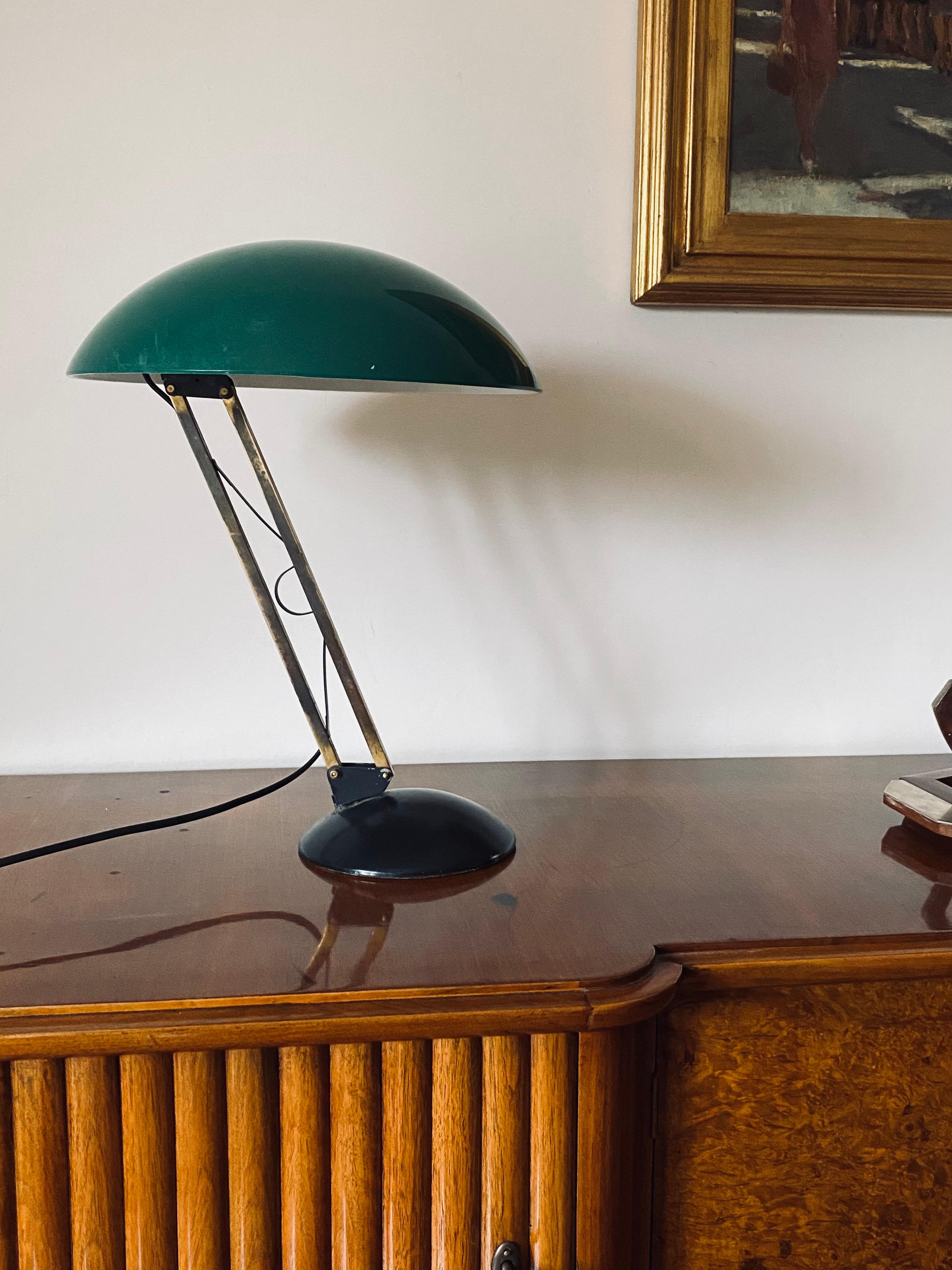 Mid-century table lamp 

Italy, 1960s

Green perspex domed shade. Brass rod. Black aluminum base

articulating arm with adjustable joints.

H 47 cm 

Diam. 37cm

Conditions: good consistent with age and use, signs of wear on the rod. In working