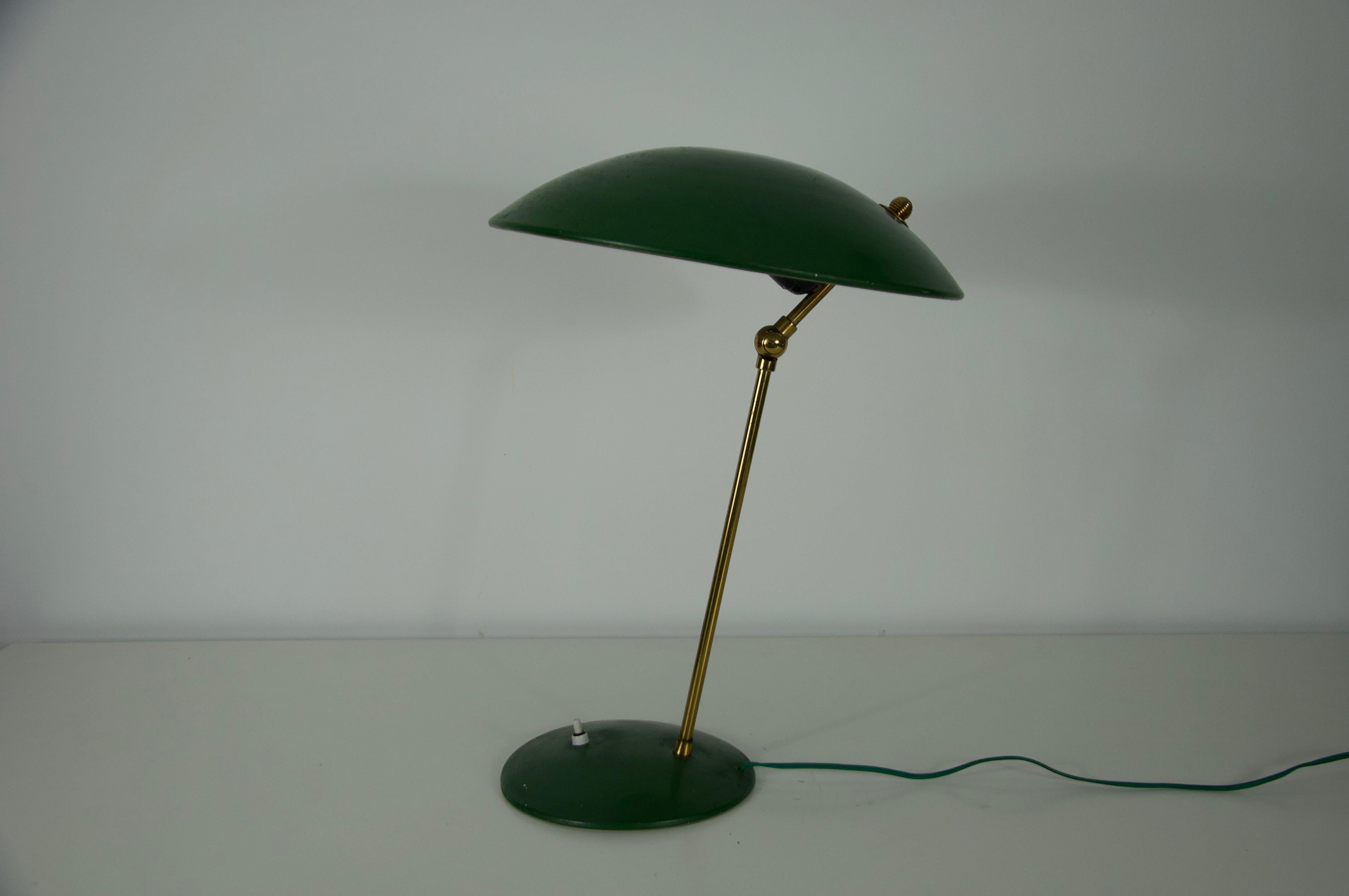 Cette élégante lampe de table italienne du milieu du siècle, datant des années 1960, présente une combinaison raffinée de laiton et de métal laqué. La finition verte frappante de la lampe et son abat-jour légèrement bombé évoquent le charme