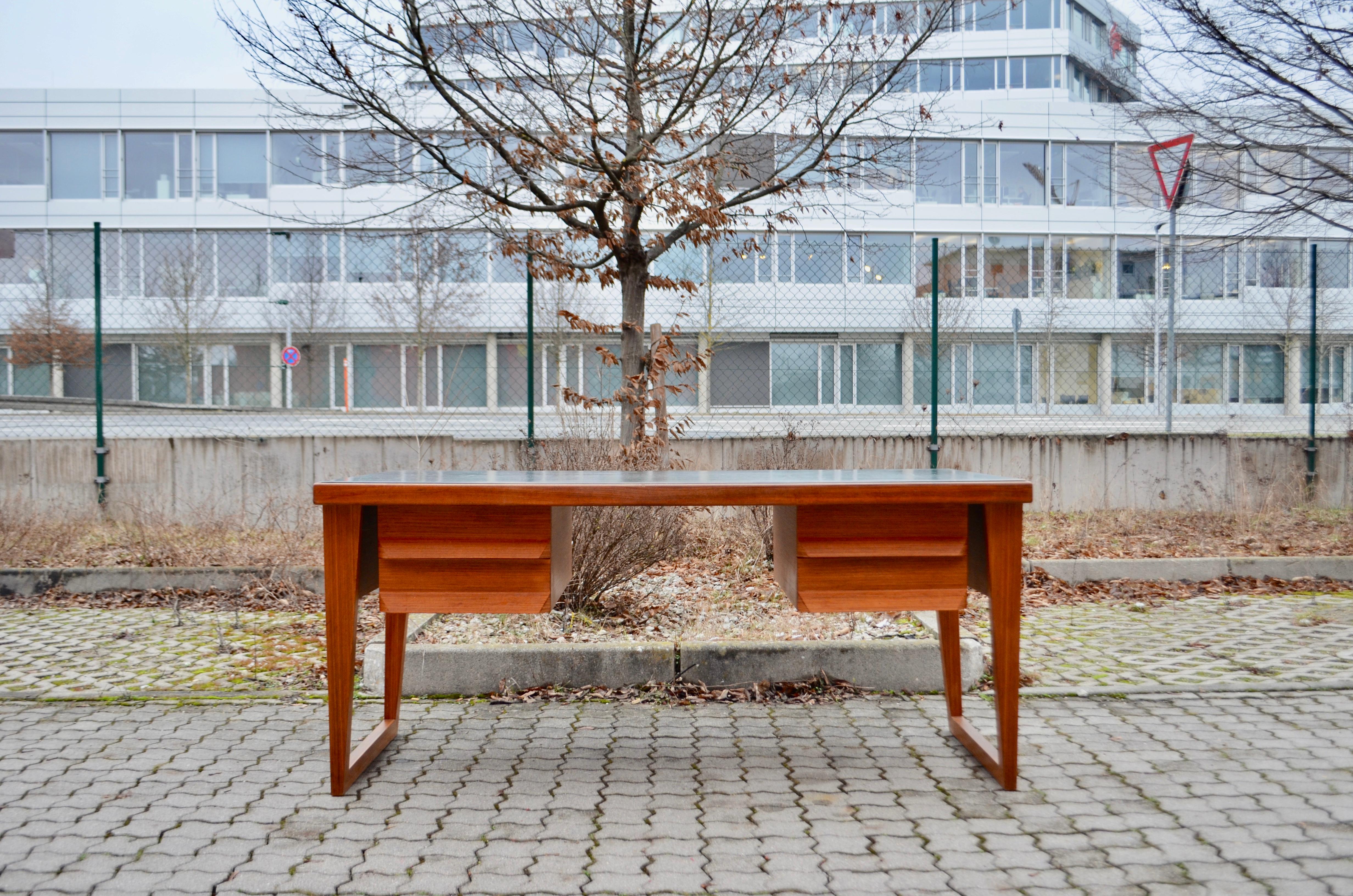 Midcentury 1960s Desk from Germany. In teak and green saddle leather top.
2 drawers on each side.
Stunning unique patina on the thick green saddle leather.
A unique extraordinary midcentury masterpiece design from Germany.
It looks light weighted