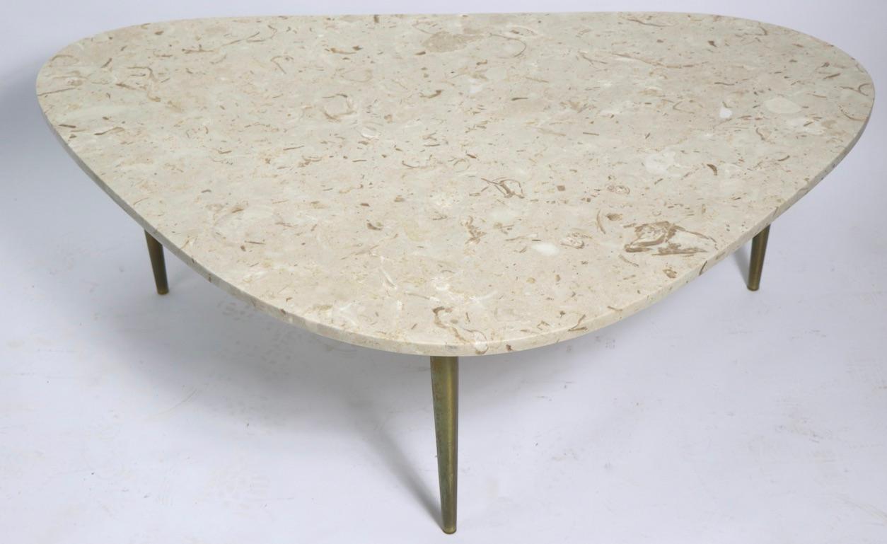 Classic mid century  marble top coffee table, on brass tapered pole legs. This example is in very good, original condition, clean and ready to use. Marble top marked ITALY, on verso - Marble top .75 in. thick. Although the top is marked ITALY, we