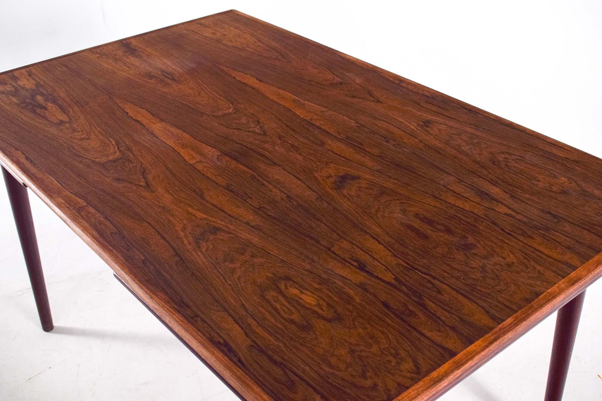 Table de salle à manger Midcentury Modern By Design/One Møbelfabrik en bois de rose 1960, Danemark, conçue par Gunni JR, avec deux rallonges. Cette magnifique table modèle 54 a un plateau rectangulaire en bois de rose plaqué et des bordures en bois