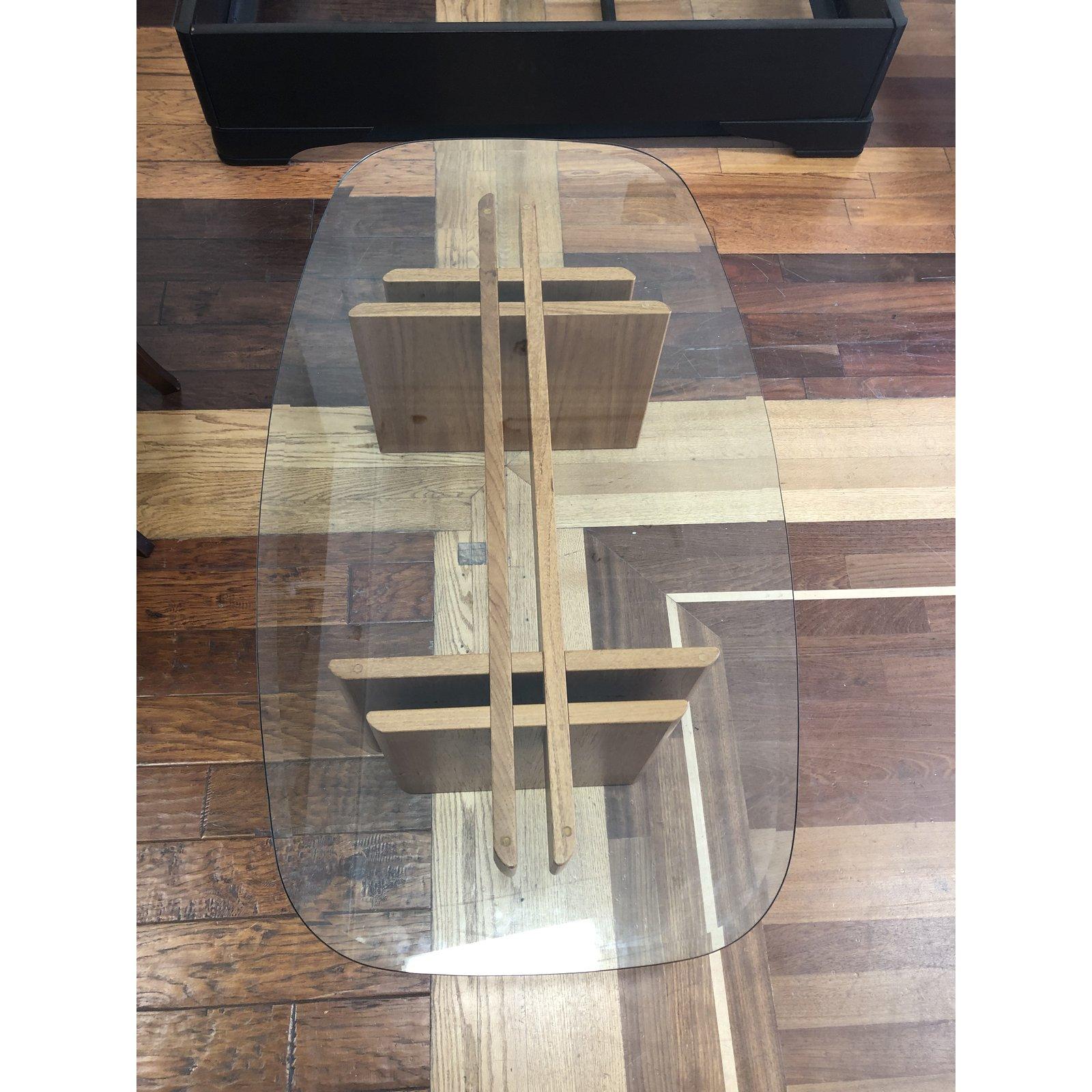 A midcentury Gustav Gaarde coffee table. Manufactured by Trekanten. The base is a interlocking teak base. A rectangular curved edge top beveled polished edge. Minor wear on the glass. Made in Denmark.