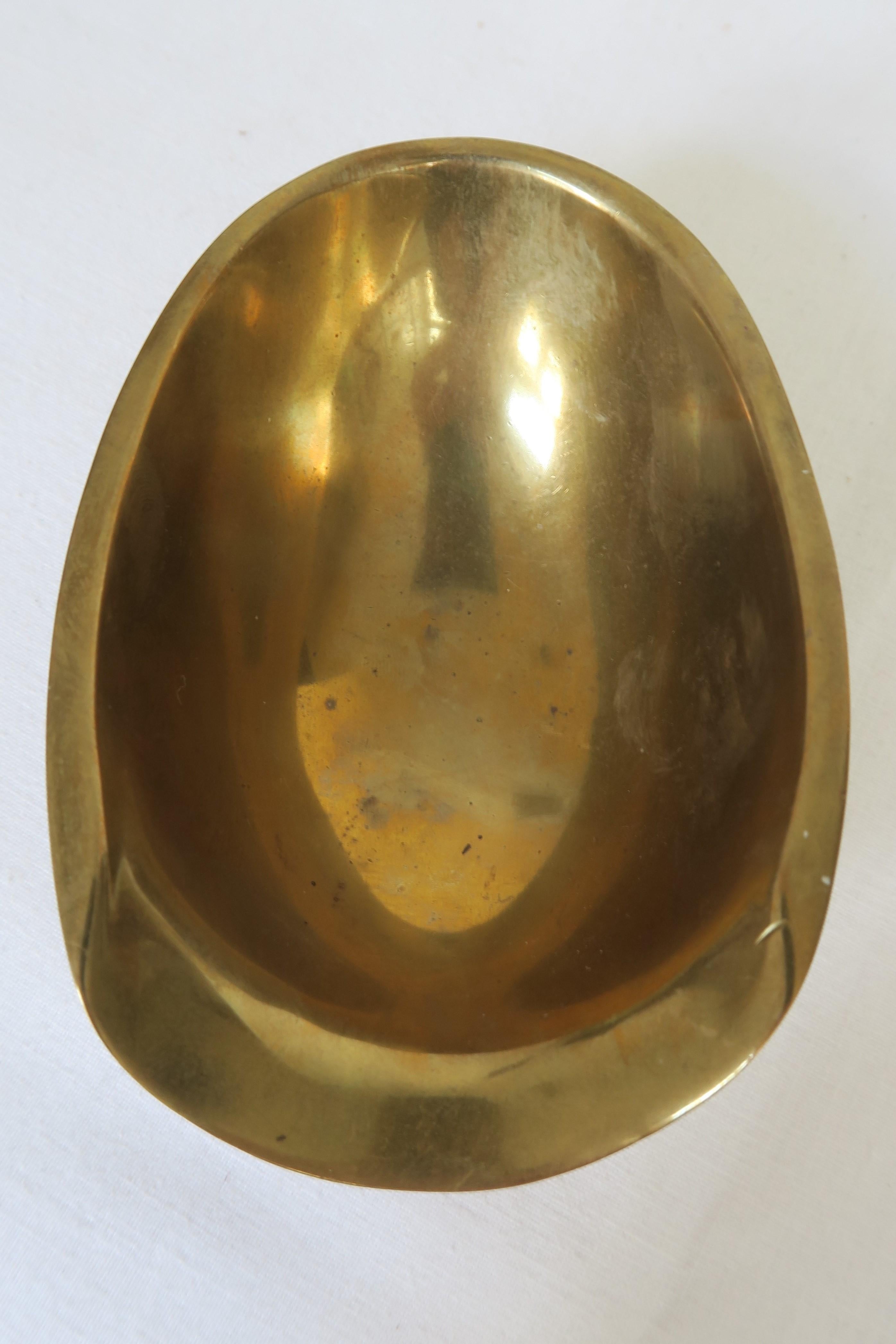 For sale is a unique piece of Mid-Century Modern design. The ashtray was mindfully cast out of solid golden-warm brass. It was produced and designed by the renowned Austrian workshops of Hagenauer Wien. The surface is polished to a shine and