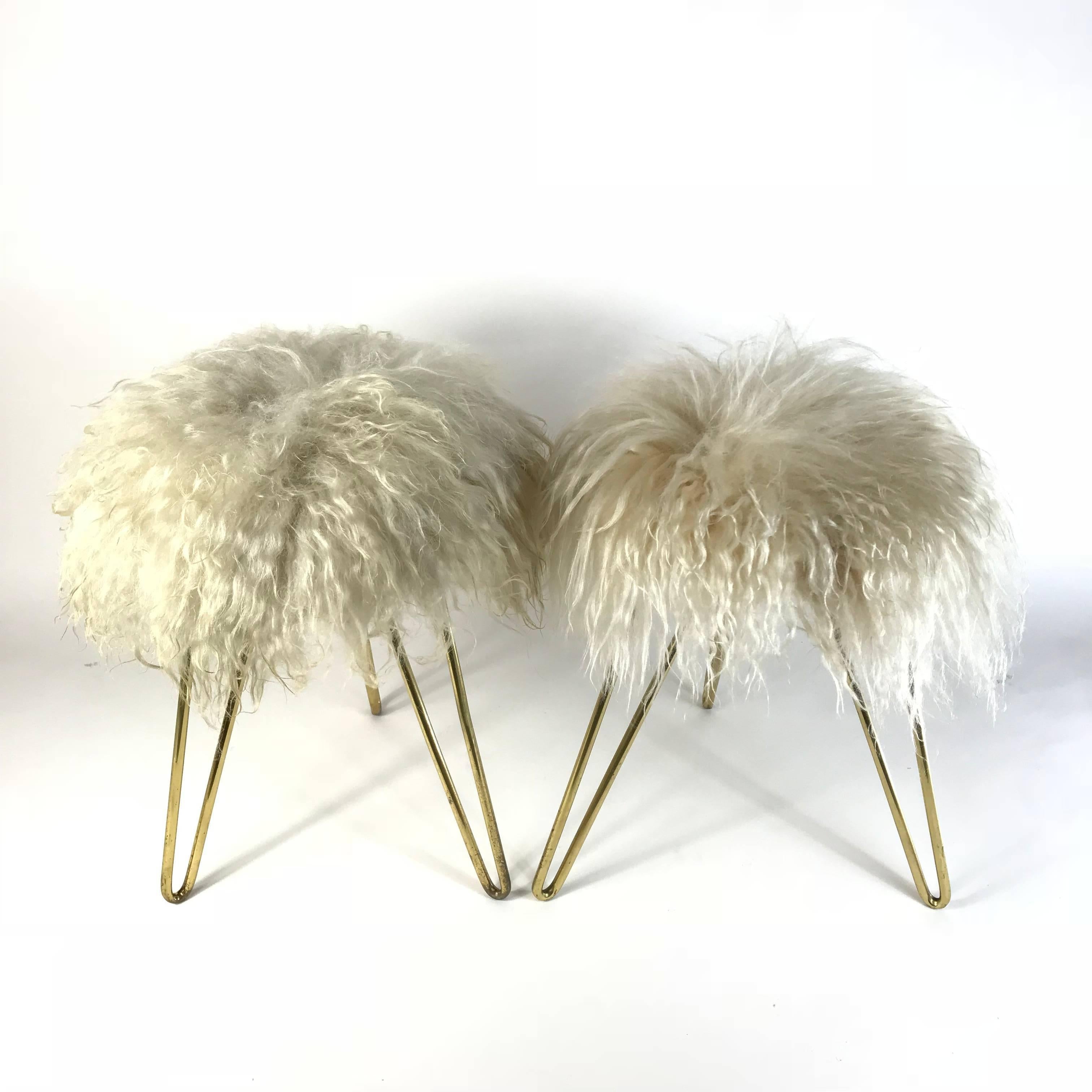 Pair of very decorative handmade French 1950s lambswool fur stools in the style of Jean Royère. The long white lambswool fur was dyed beige to intensify the visual depth, and the three brass hairpin legs serve as a reduced, minimalist counterpart to