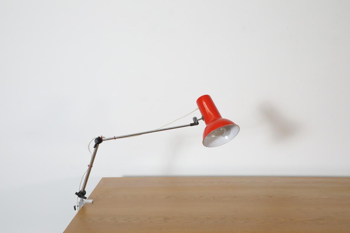 Mid-Century industrial clamp on table lamp with bright red dome shade. Drafting lamp on double adjustable chrome stem and aluminum clamp. In original condition with wear and scratching consistent with age and use, including some enamel loss. Other