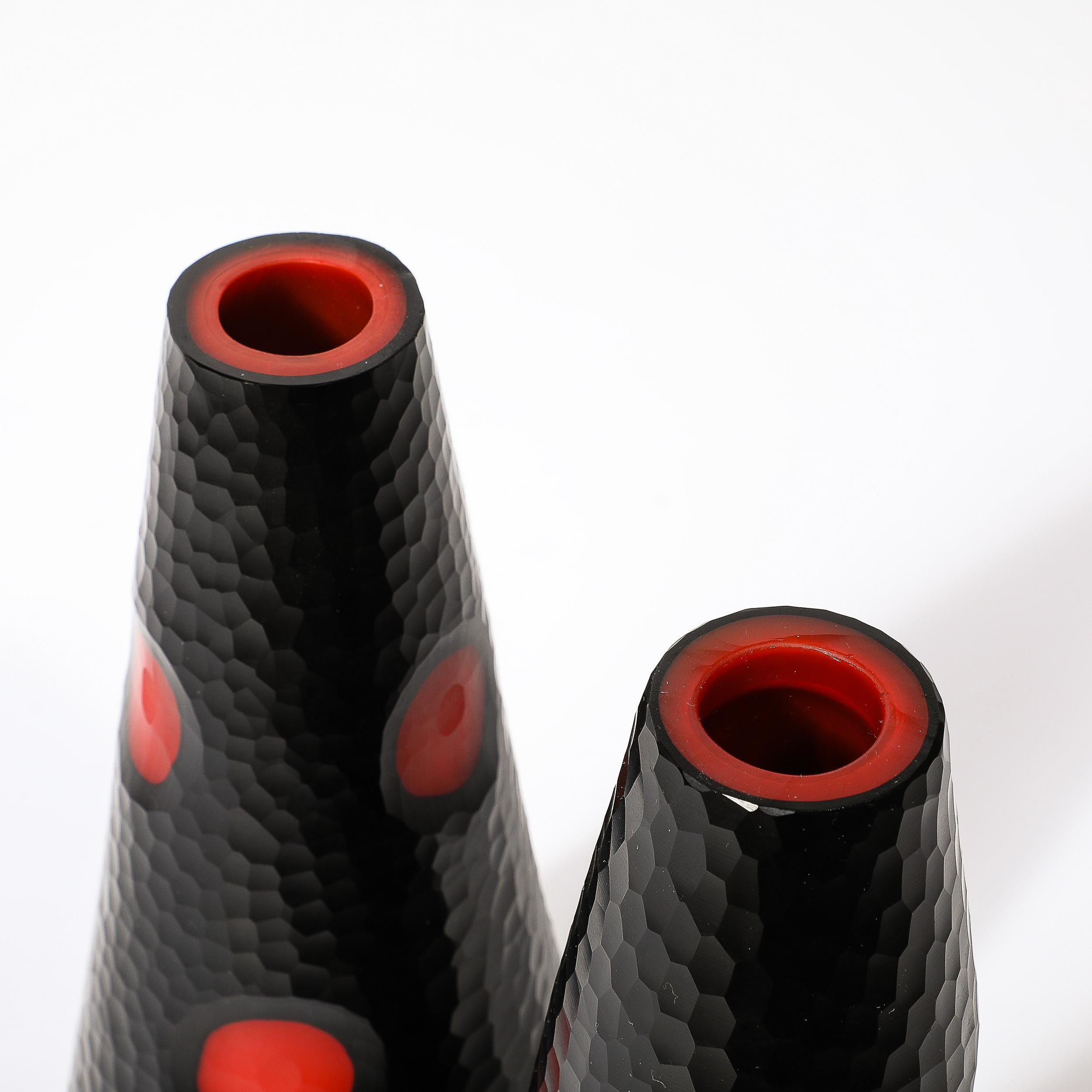 This lovely Pair of Mid-Century Modernist Hand-Blown Murano Battuto Glass Vases in Black W/Vermillion Detailing originates from Italy, Circa 1980. Featuring a tapered form with battuto textural detailing throughout, with regularly spaced concave