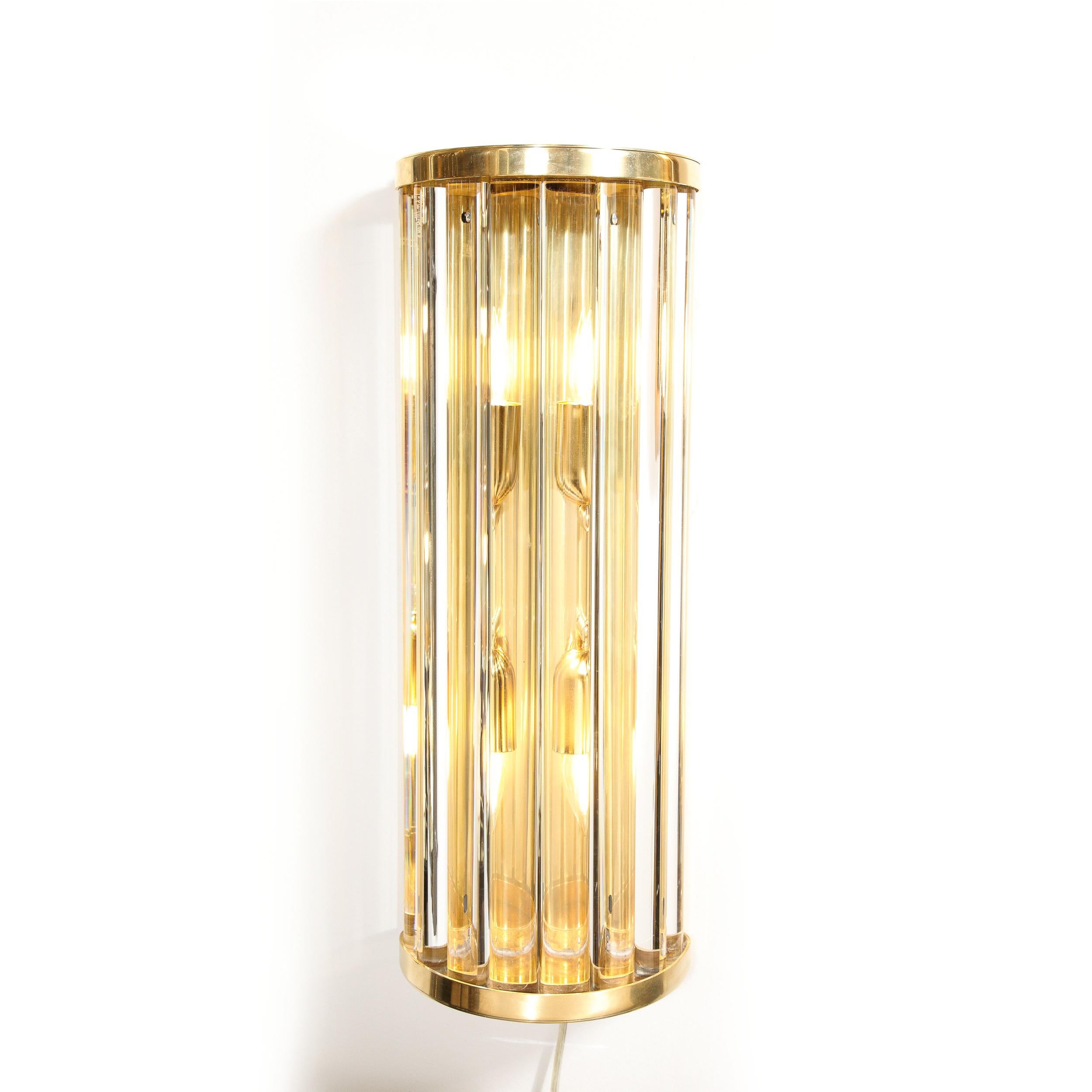 This Pair of Mid-Century Modernist Sconces in Glass Rods and Brass fittings were created by Toso Murano and originate from Italy during the latter half of the 20th Century. Featuring gorgeous translucent glass rods in a curved demilune frame in