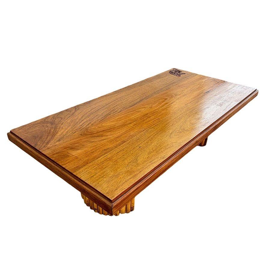 Table basse en bois de Koa des années 1950 avec pieds en rotin empilés et motif d'anthurium sculpté à la main le long de l'angle. Cette superbe table basse des années 1950 met en valeur la beauté intemporelle du bois de koa, réputé pour son grain