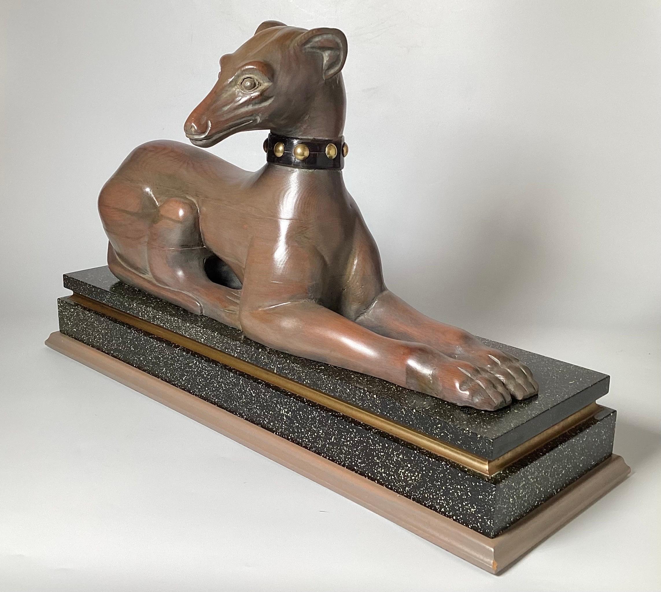 Elegant hand carved sculpture of a whippet on original faux stone painted base. The whippet with painted collar, the body showing warm polished wood and a beautiful wood grain. Made in Spain, mid 20th Century, marked on bottom from the original