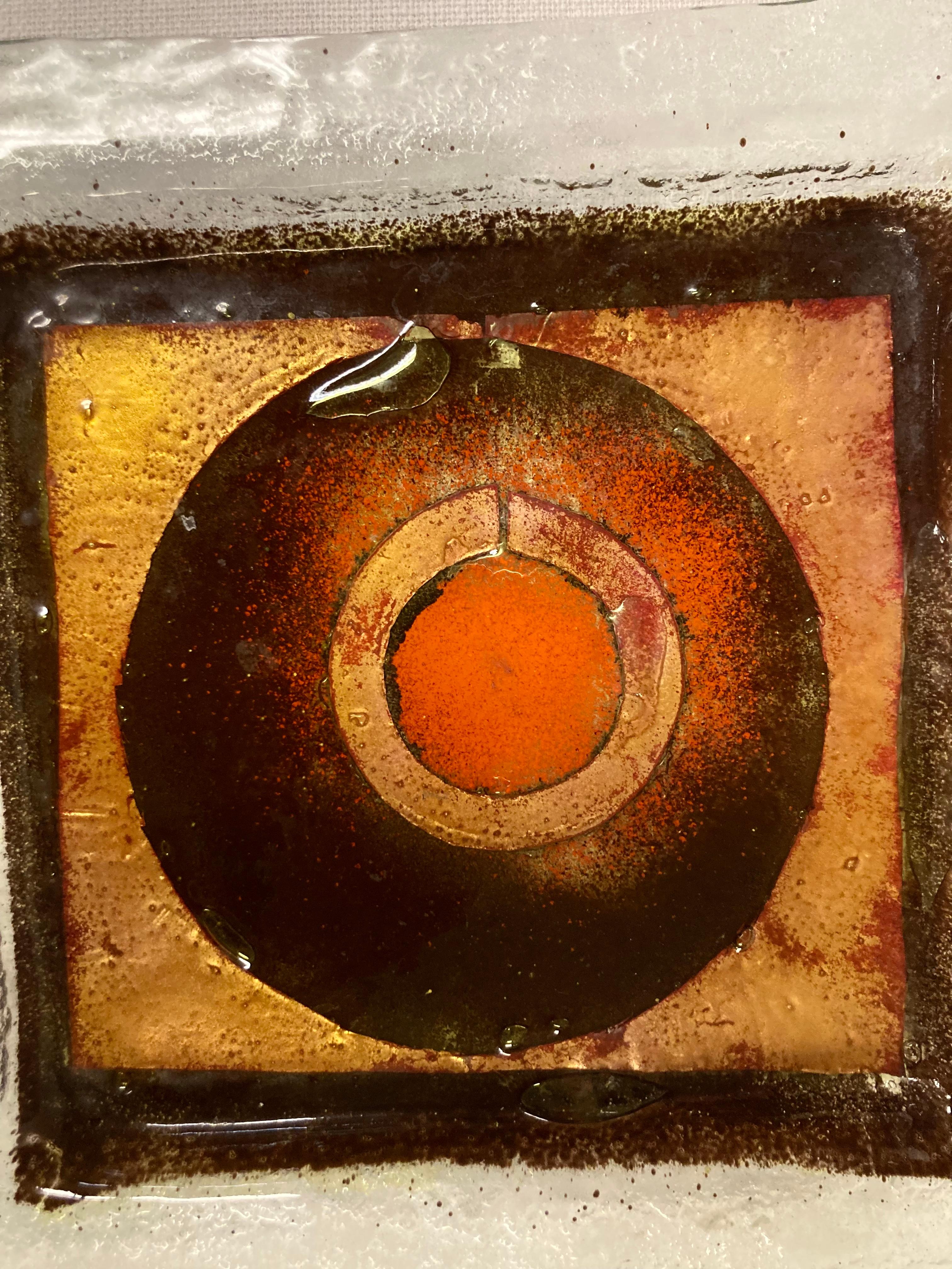 Un suggestivo e colorato piatto in vetro lavorato a mano con dorature e colori applicati. Risalente agli anni '70 e caratterizzato da uno stile astratto e libero, il piatto presenta un elemento centrale rotondo di colore arancione circondato da un
