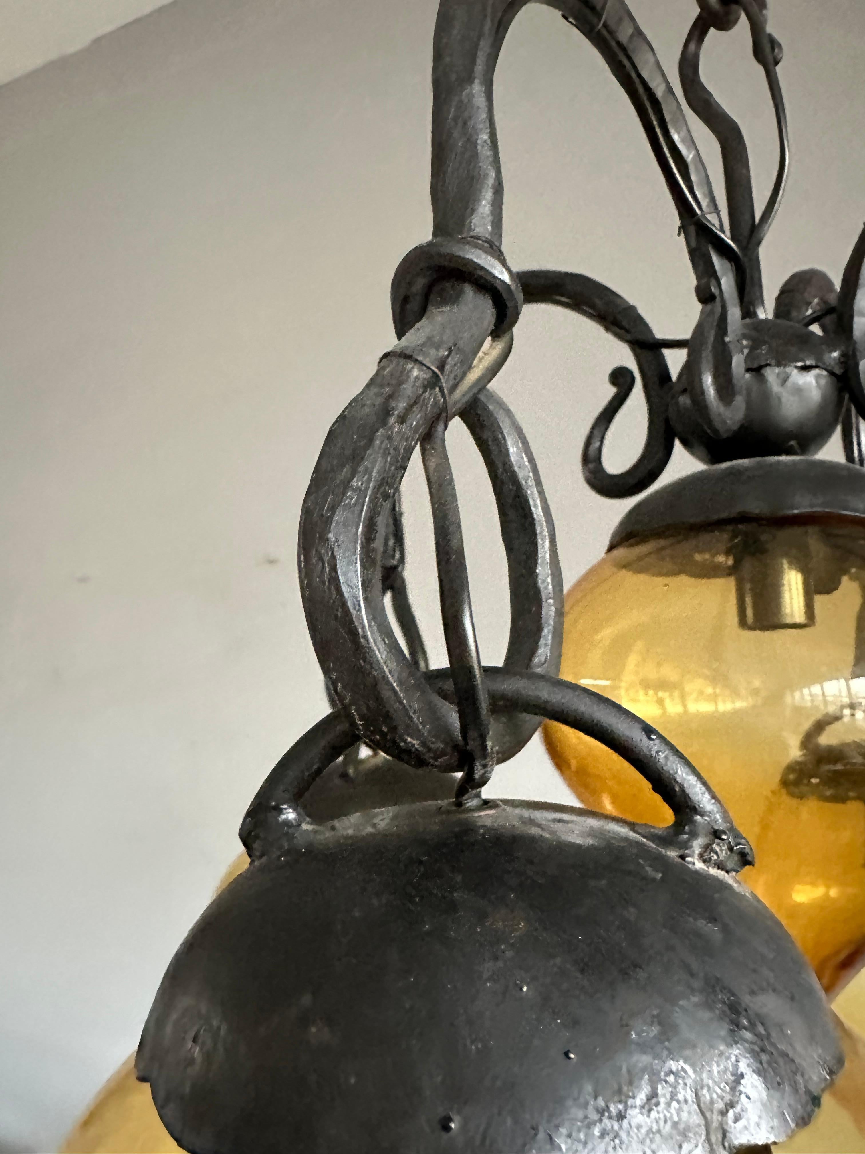 Lustre en fer forgé du milieu du siècle, forgé à la main, avec. Cinq abat-jour en verre soufflé ambré en vente 5
