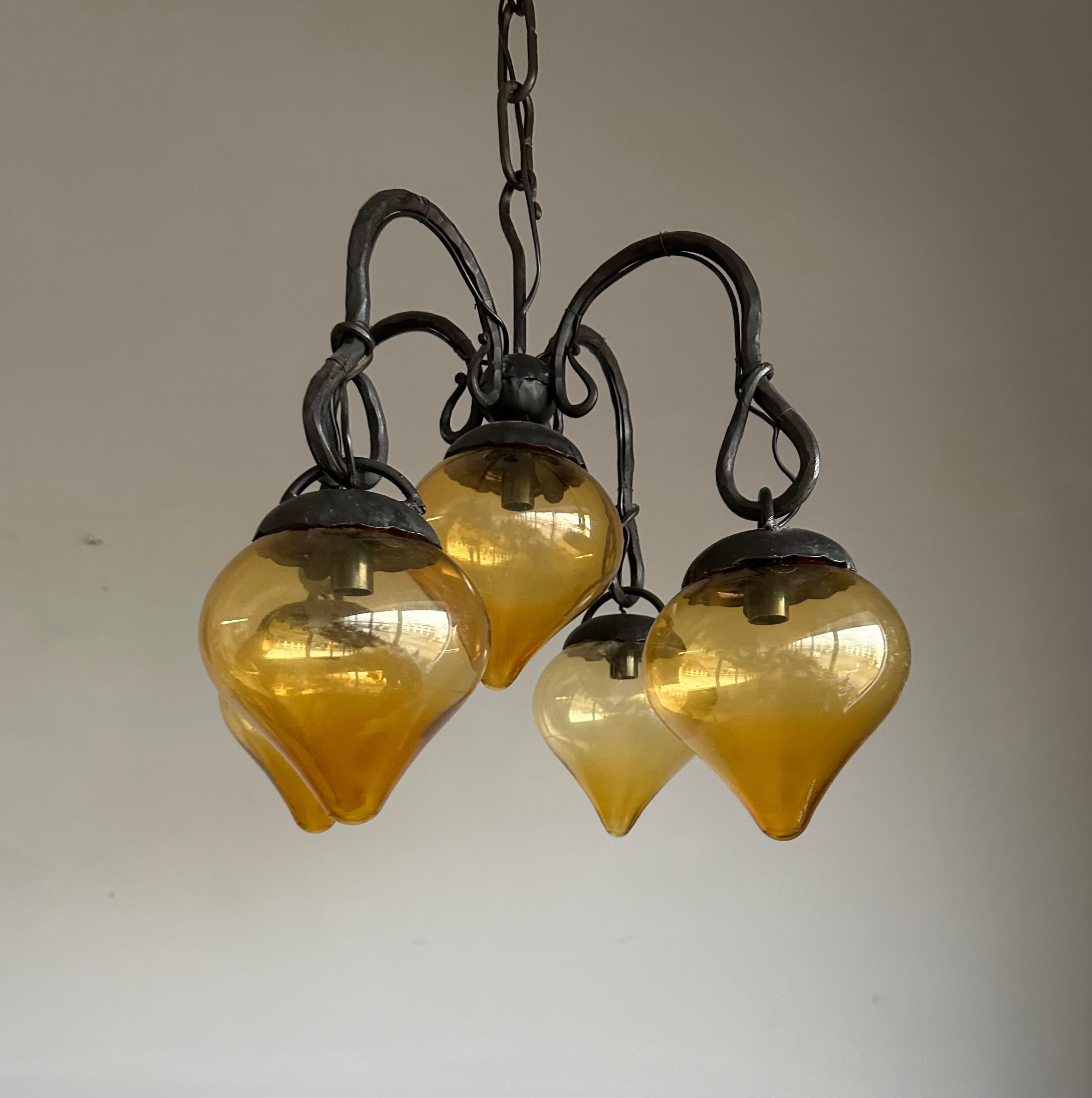 Lustre en fer forgé du milieu du siècle, forgé à la main, avec. Cinq abat-jour en verre soufflé ambré en vente 6