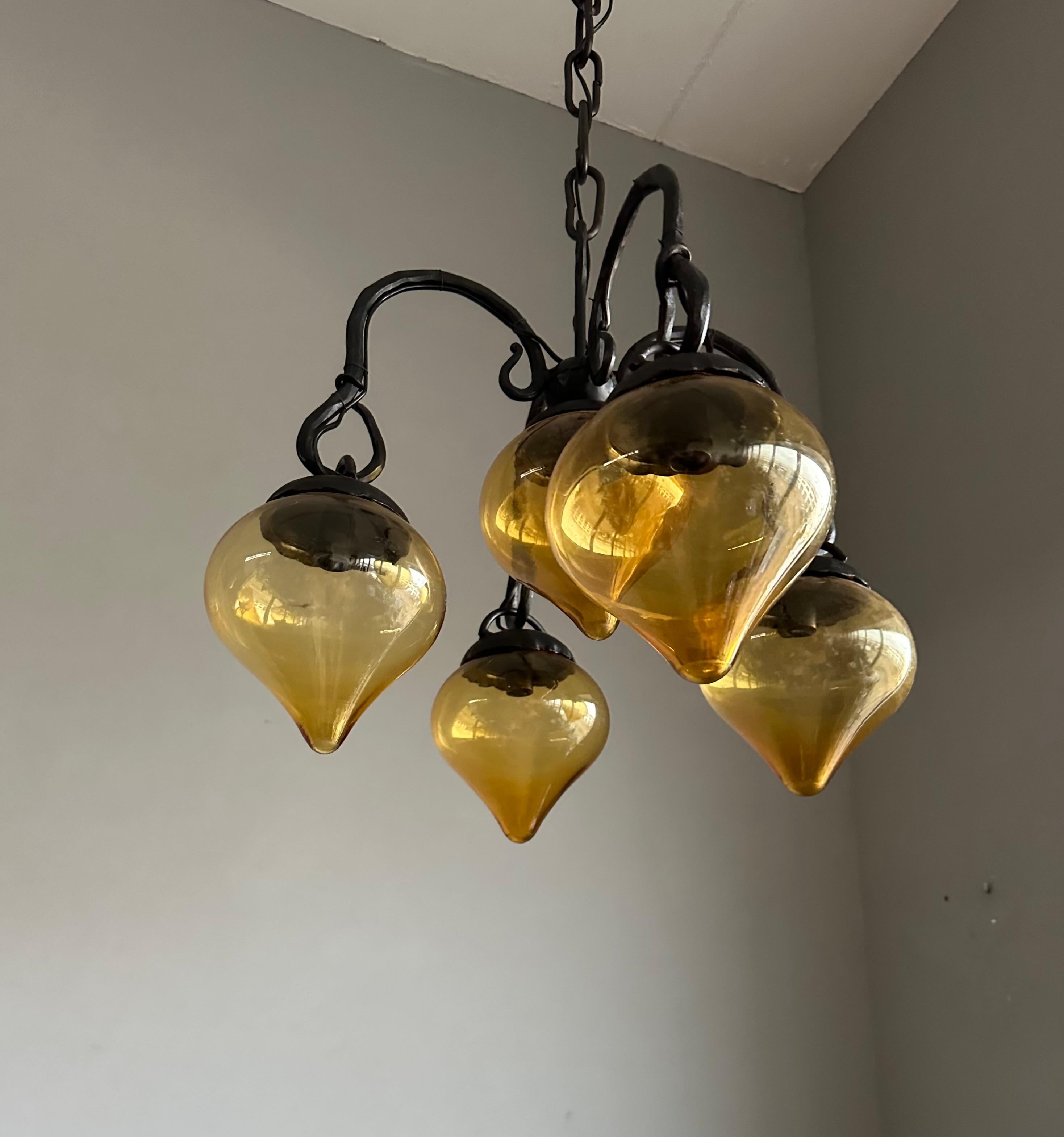 Lustre en fer forgé du milieu du siècle, forgé à la main, avec. Cinq abat-jour en verre soufflé ambré en vente 8