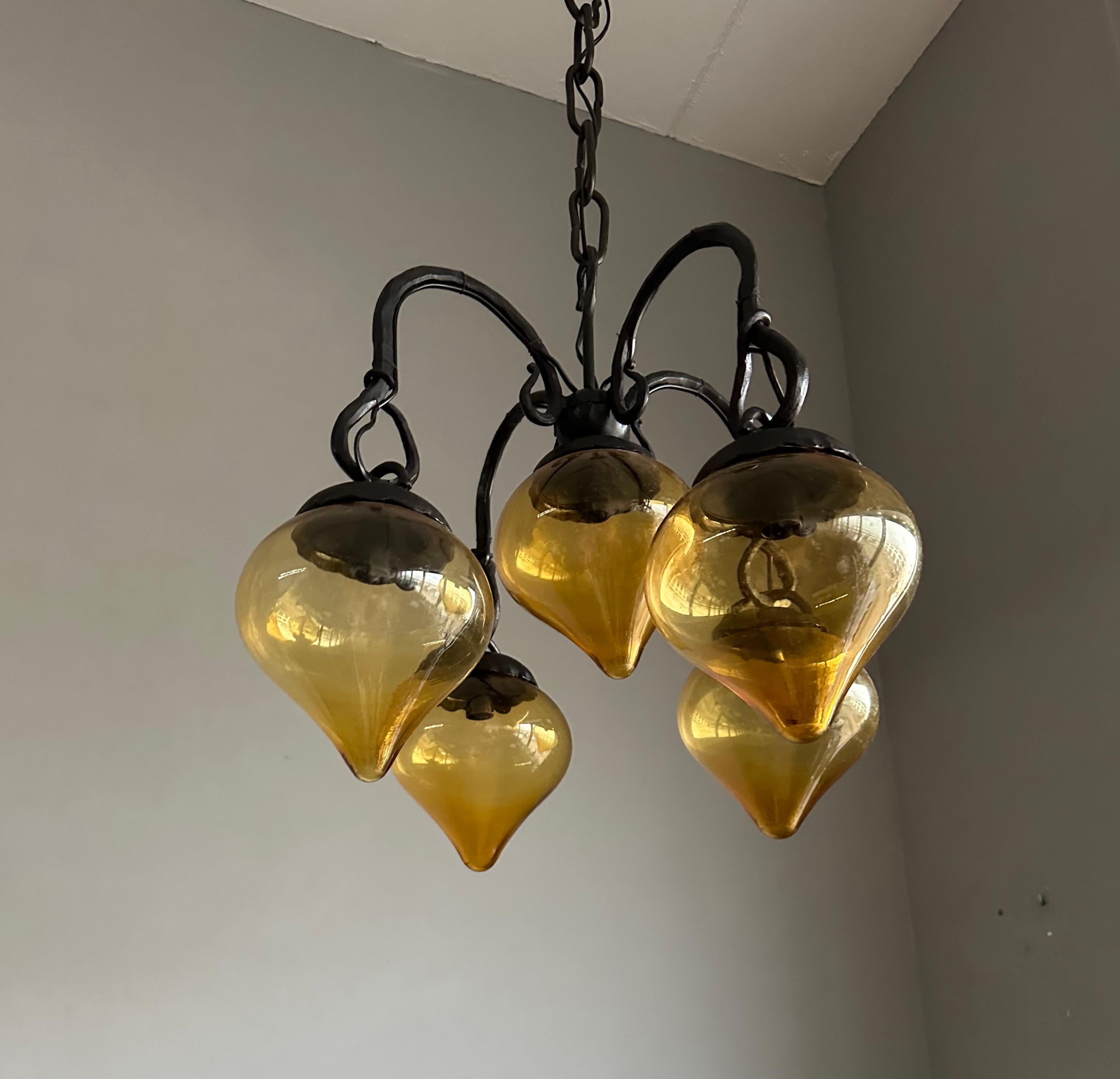 Lustre en fer forgé du milieu du siècle, forgé à la main, avec. Cinq abat-jour en verre soufflé ambré en vente 9