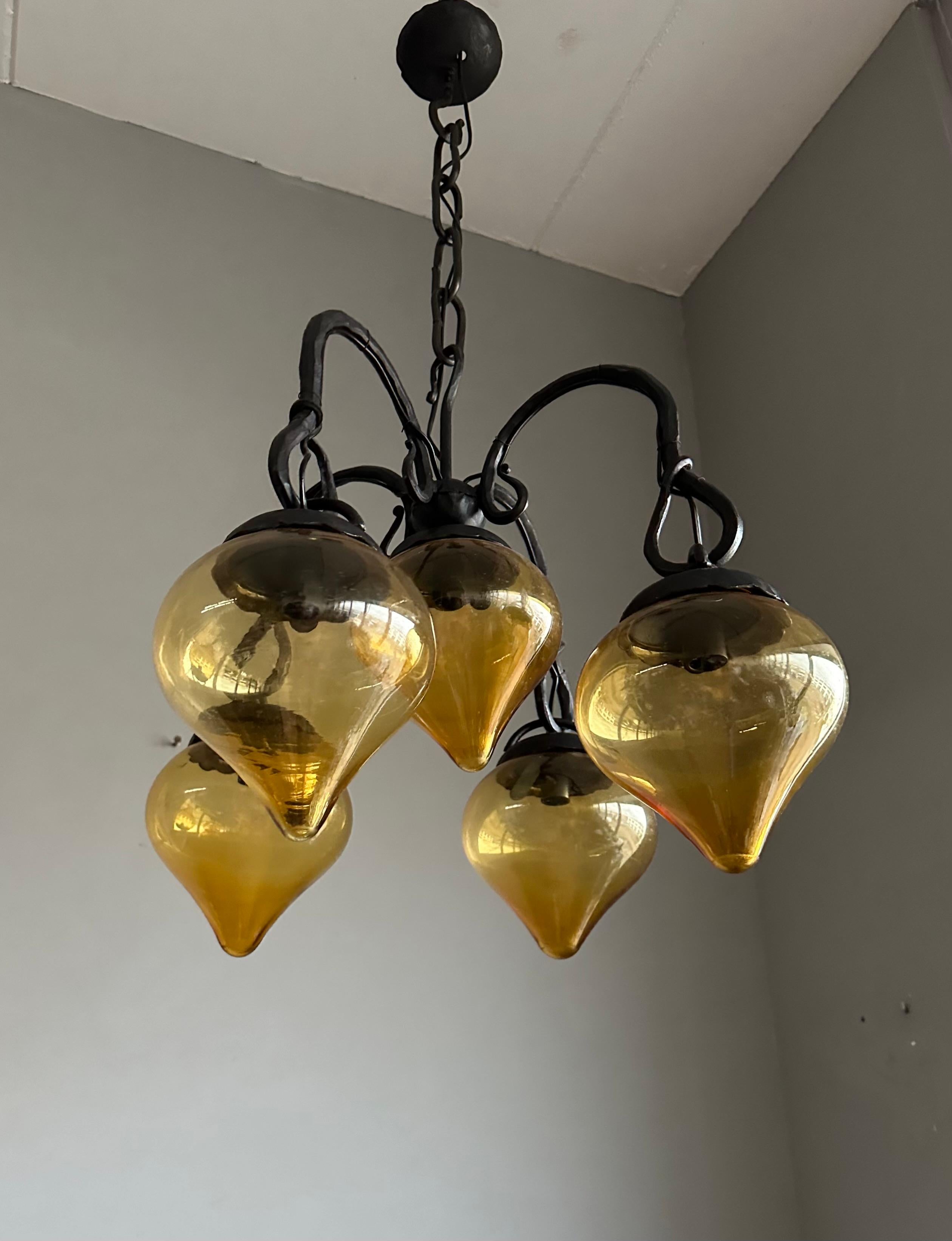 Lustre en fer forgé du milieu du siècle, forgé à la main, avec. Cinq abat-jour en verre soufflé ambré en vente 10