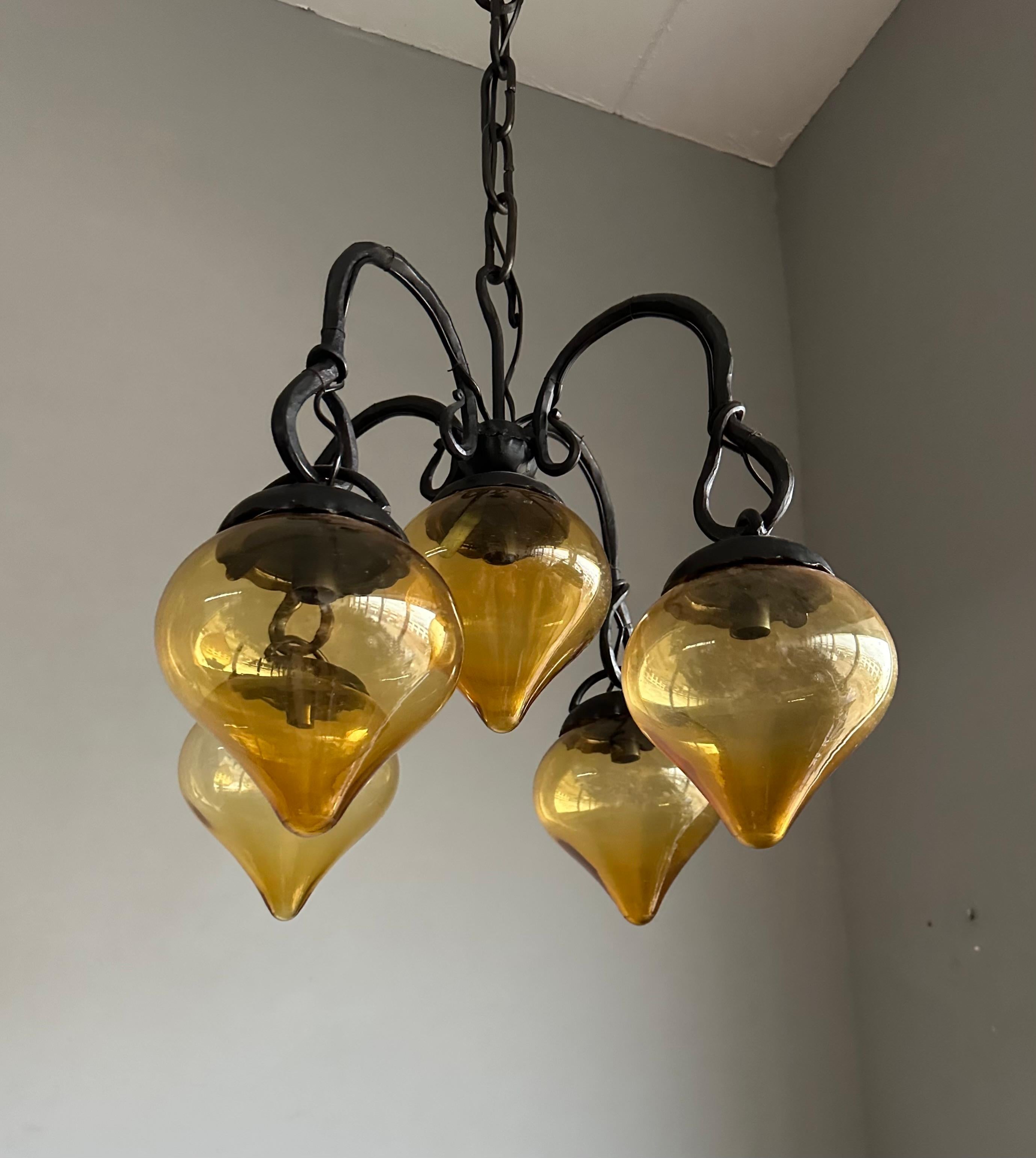 Européen Lustre en fer forgé du milieu du siècle, forgé à la main, avec. Cinq abat-jour en verre soufflé ambré en vente