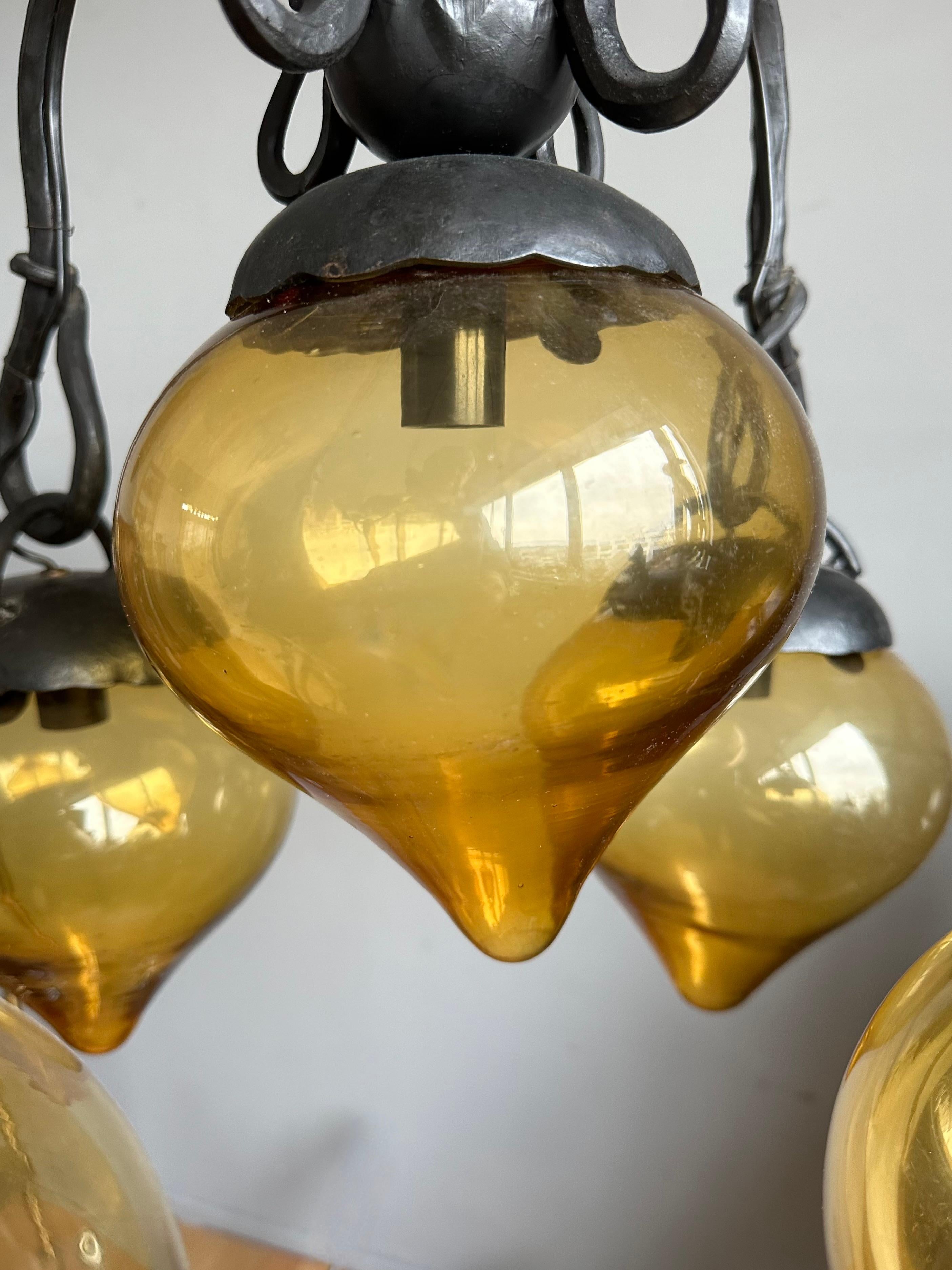 Lustre en fer forgé du milieu du siècle, forgé à la main, avec. Cinq abat-jour en verre soufflé ambré Excellent état - En vente à Lisse, NL