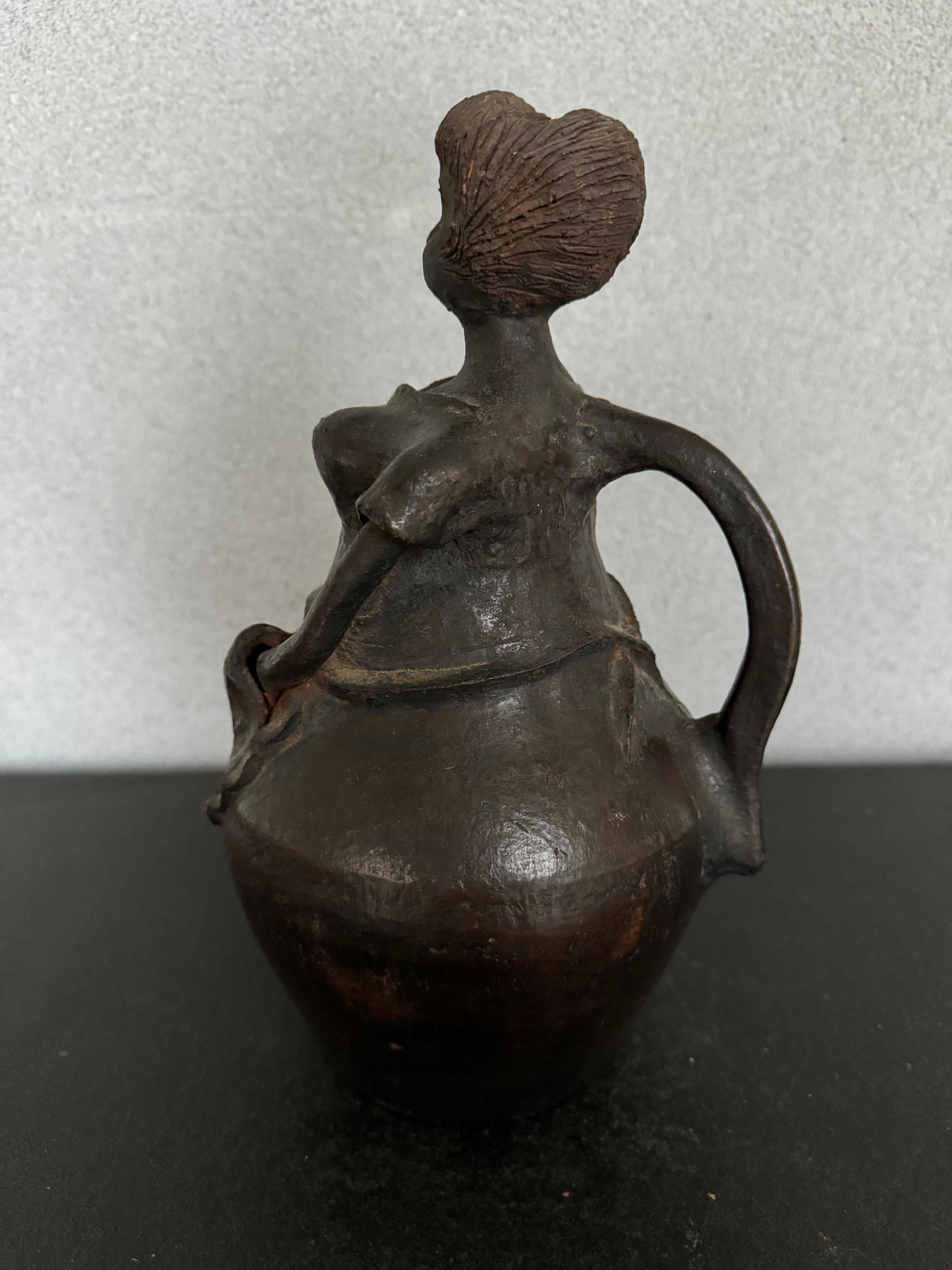 Rare and unique Mid-Century pottery piece, shape as a women with an apron, has a handle like a pitcher but it’s not an actual pitcher, also has a hole at top of the head but there is not opening for liquid to pour 
Acquired at and estate sale and