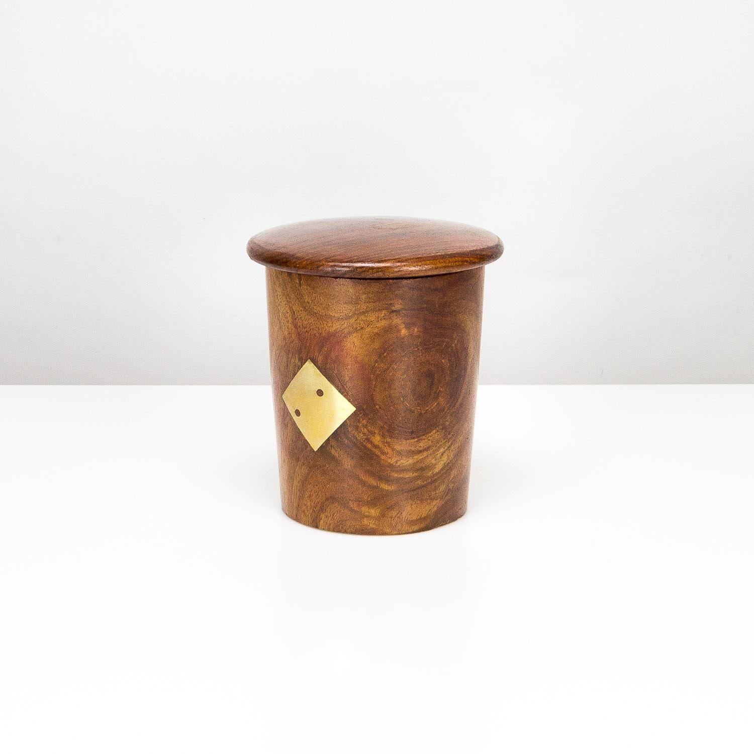 A midcentury dice cup in teak and brass inlay with lid and set of 5 dice. The dice are also teak with brass number pips. Brass decorations to the outside showing numbers one and two. Handmade, Denmark, 1960s.