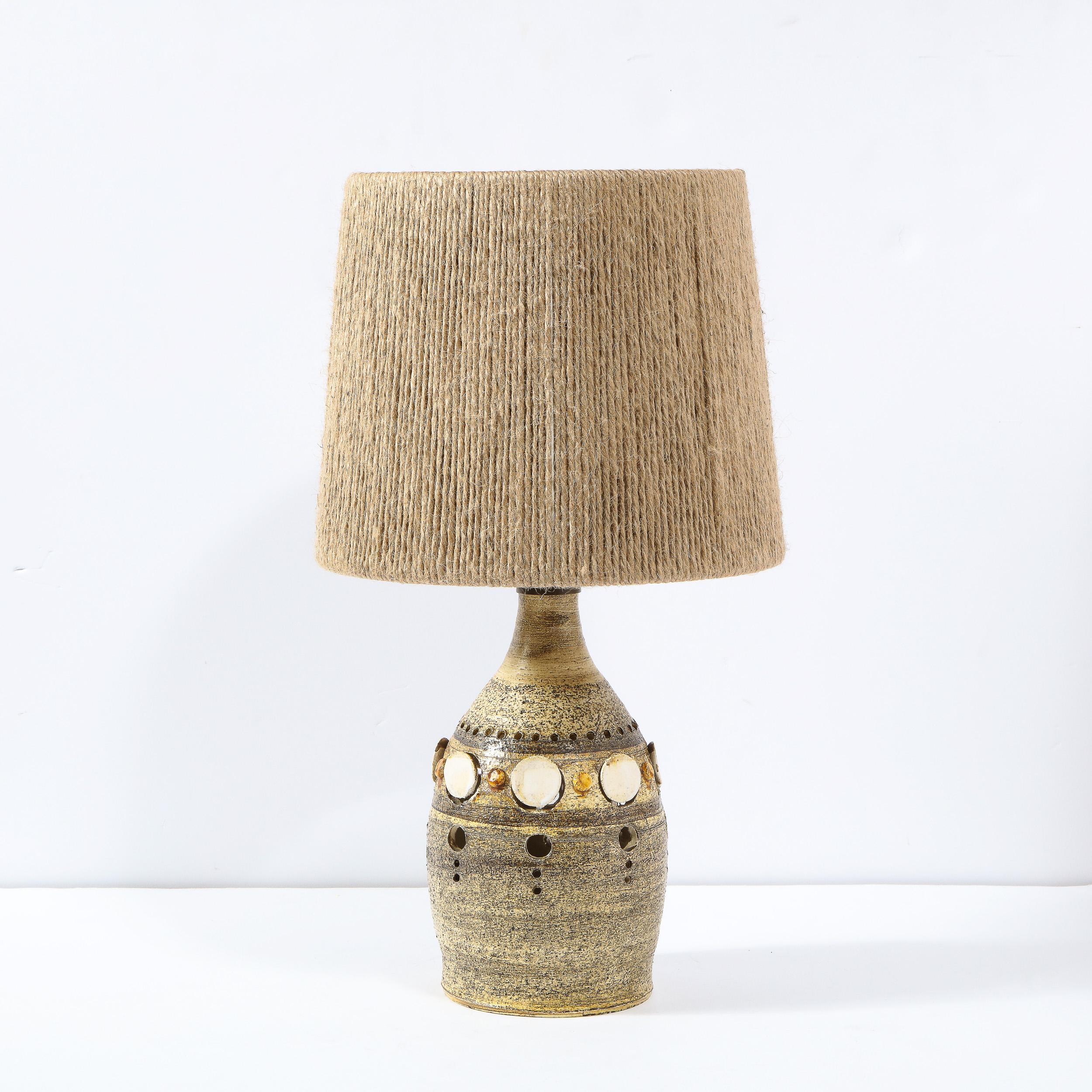 This sophisticated Mid-Century Modern table lamp was realized by the acclaimed designed Georges Pelletier in France, circa 1950. It features a conical ceramic body hand painted in a rich espresso hue with chestnut accents throughout and circular cut