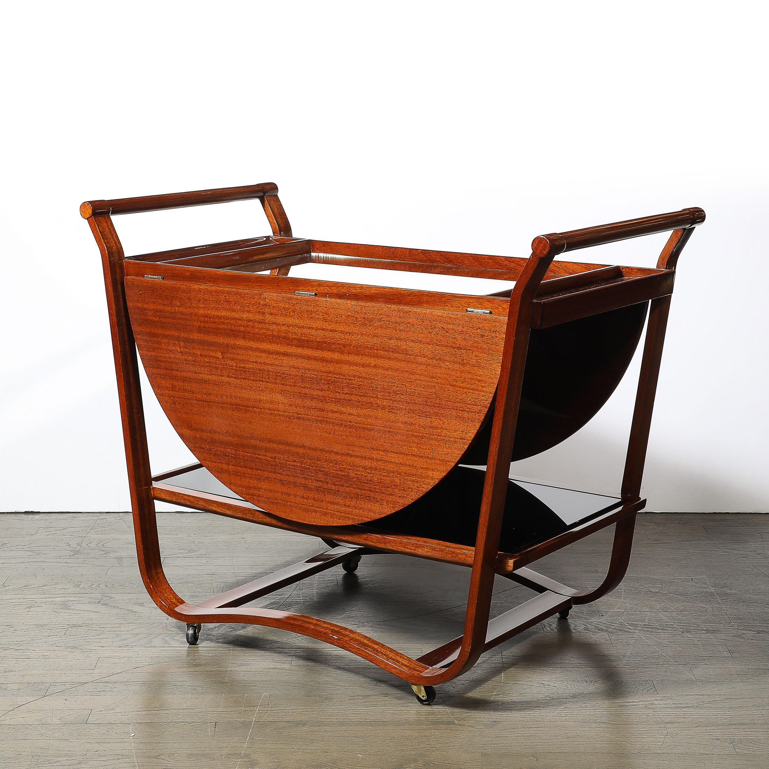 Ce chariot de bar à abattant en noyer de style moderniste du milieu du siècle a été créé par l'illustre designer Edward Wormley pour Dunbar, aux États-Unis, vers 1950. Avec une belle combinaison de bois courbé et de formes géométriques simplifiées