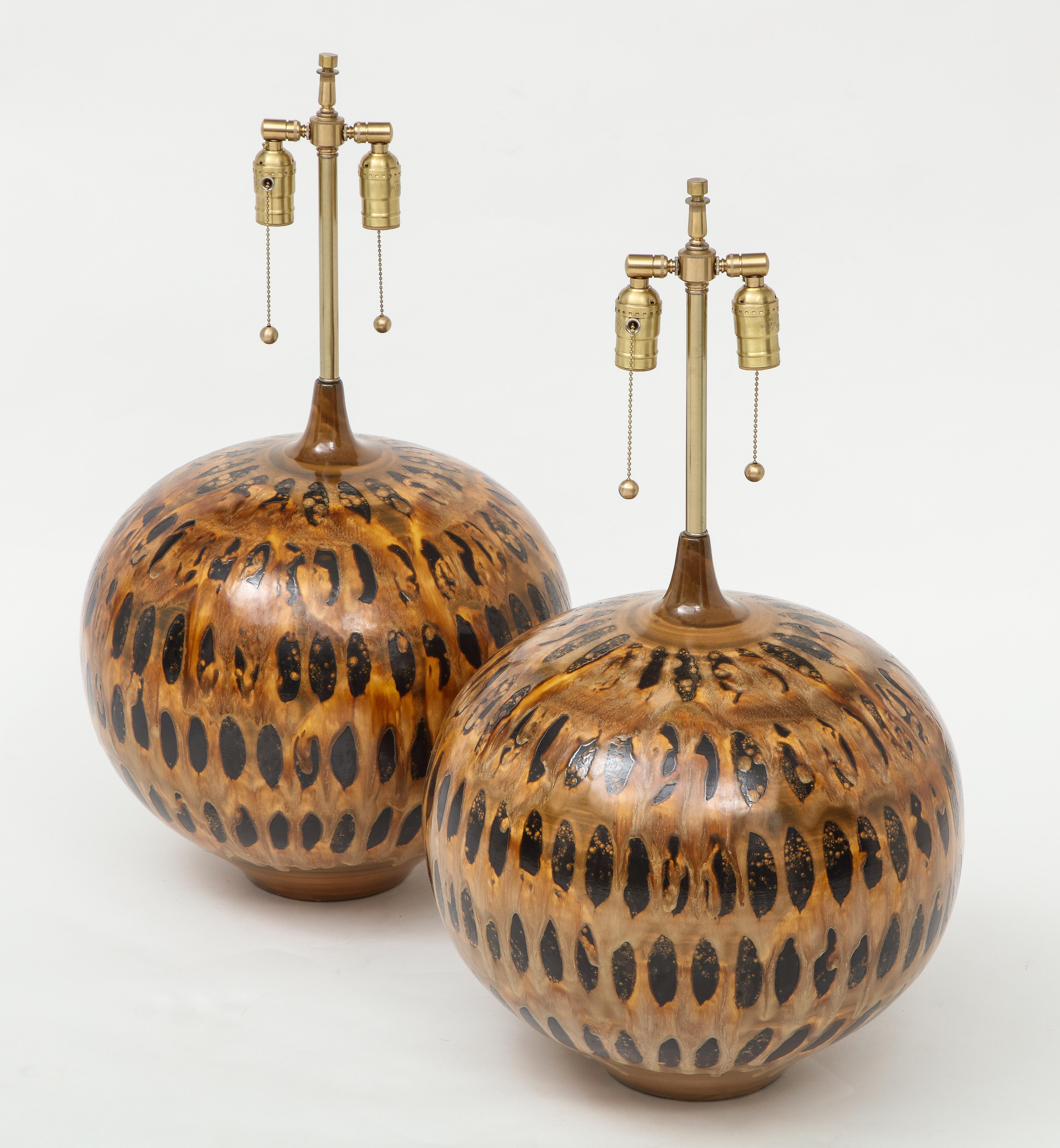 Pair of large scale David Cressey style onion shaped hand built ceramic lamps with a stylized tortoise shell glaze featuring earthtone colors ranging from umbers to sienna. Rewired with double pull chain sockets and clear cord.