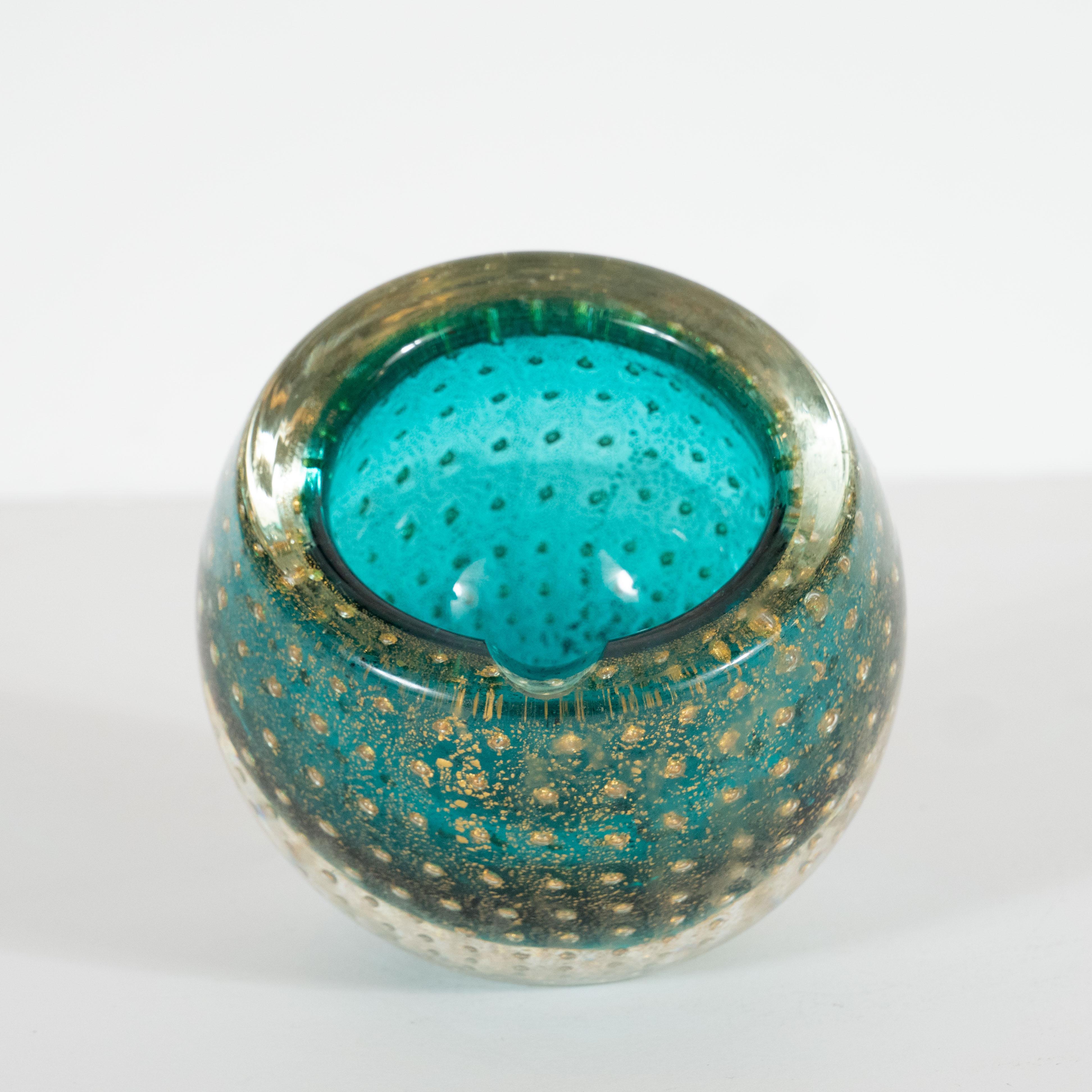 This elegant decorative bowl or ashtray was handblown in Murano, Italy- the island off the coast of Venice renowned for its superlative glass production, circa 1960. It features a spherical body with a circular mouth cut a bias with a translucent