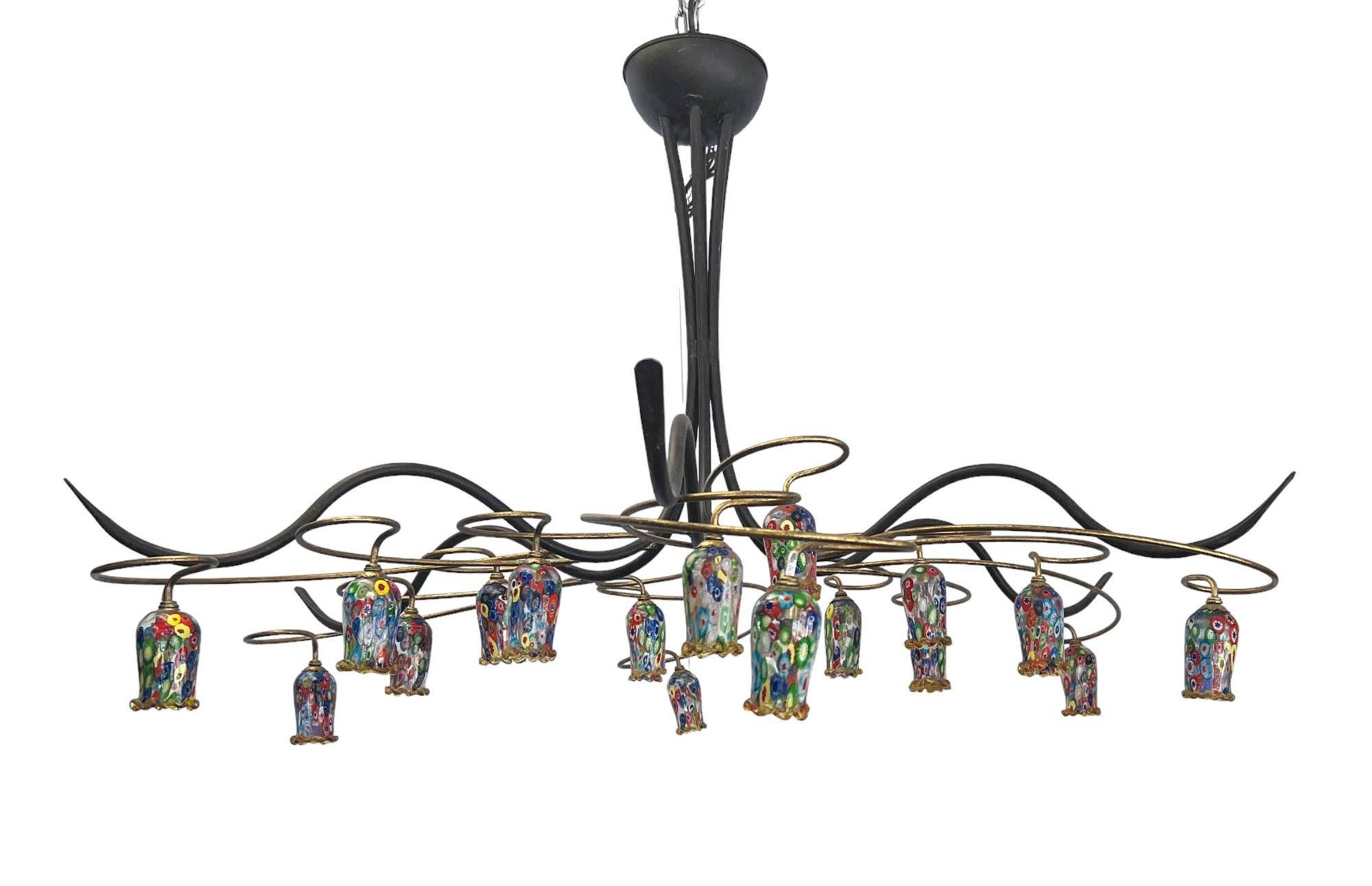 Un lampadario a sei bracci in ferro e rame del Mid-Century, unico nel suo genere e realizzato a mano. Ogni braccio ha tre ramoscelli di rame a forma di voluta da cui pende una coppa Millefiori, in vetro di Murano/Italia.