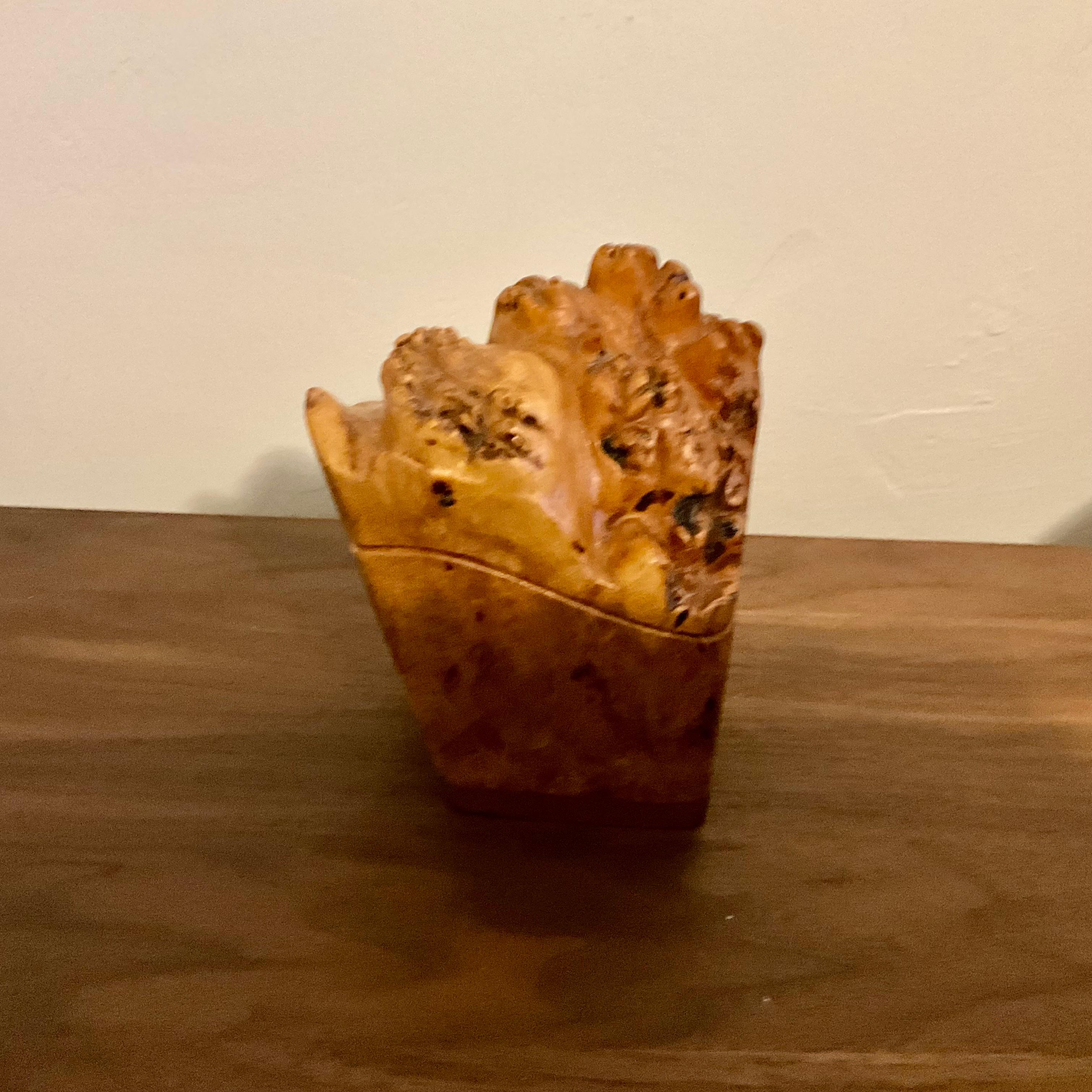 This handcrafted lidded box made from knotty burl wood is a beautiful example of artisanal craftsmanship. Standing at 5 inches tall, its unique grain and treelike form enhance its natural elegance, making it a perfect decorative piece. The artist's