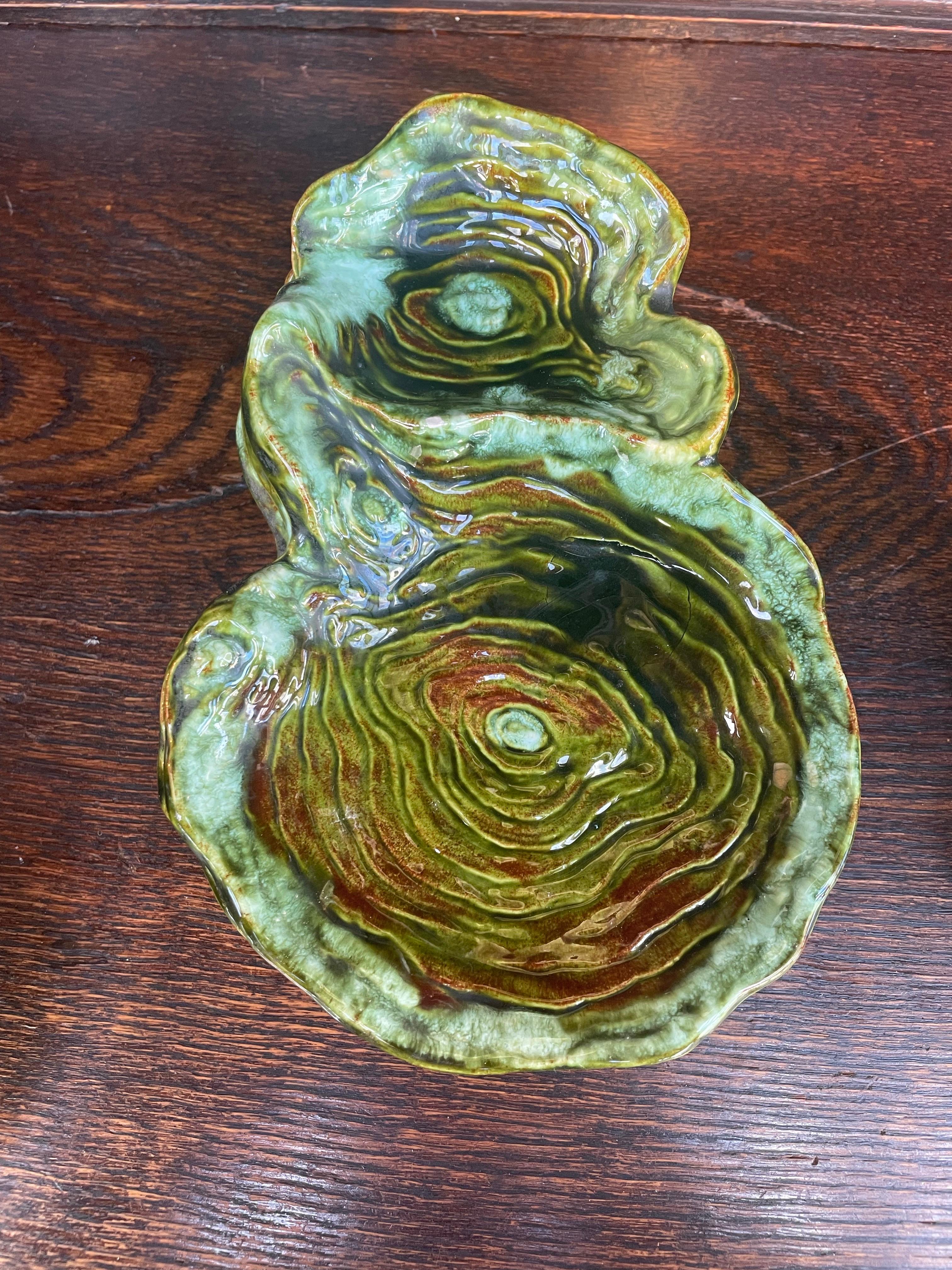 
Service unique en céramique du milieu du siècle, fait à la main, signé Eloise, 1961. Chaque pièce présente un design organique et sculptural en forme d'anneau d'arbre, avec de riches glaçures vert mousse et ambre qui imitent les veines naturelles