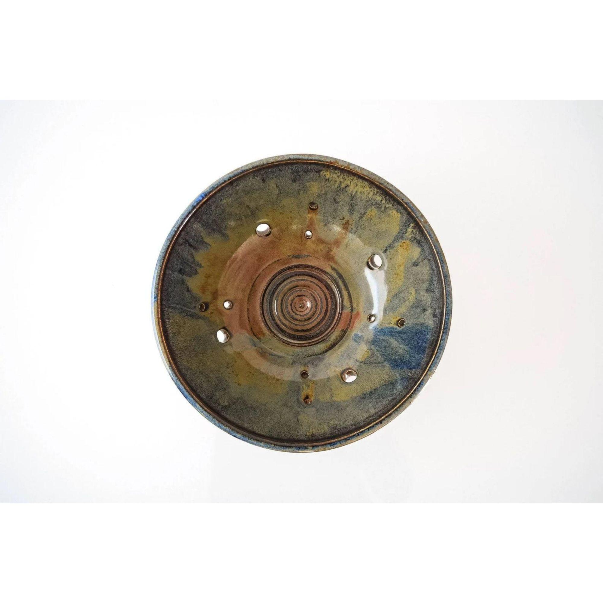 Vintage Mid Century Handcrafted Ceramic Decorative Bowl

This vintage Mid-Century Modern ceramic pottery bowl circa 1960 is beautifully handcrafted. The distinctive modernist design features accent holes, center rings, a pedestal base and gorgeous