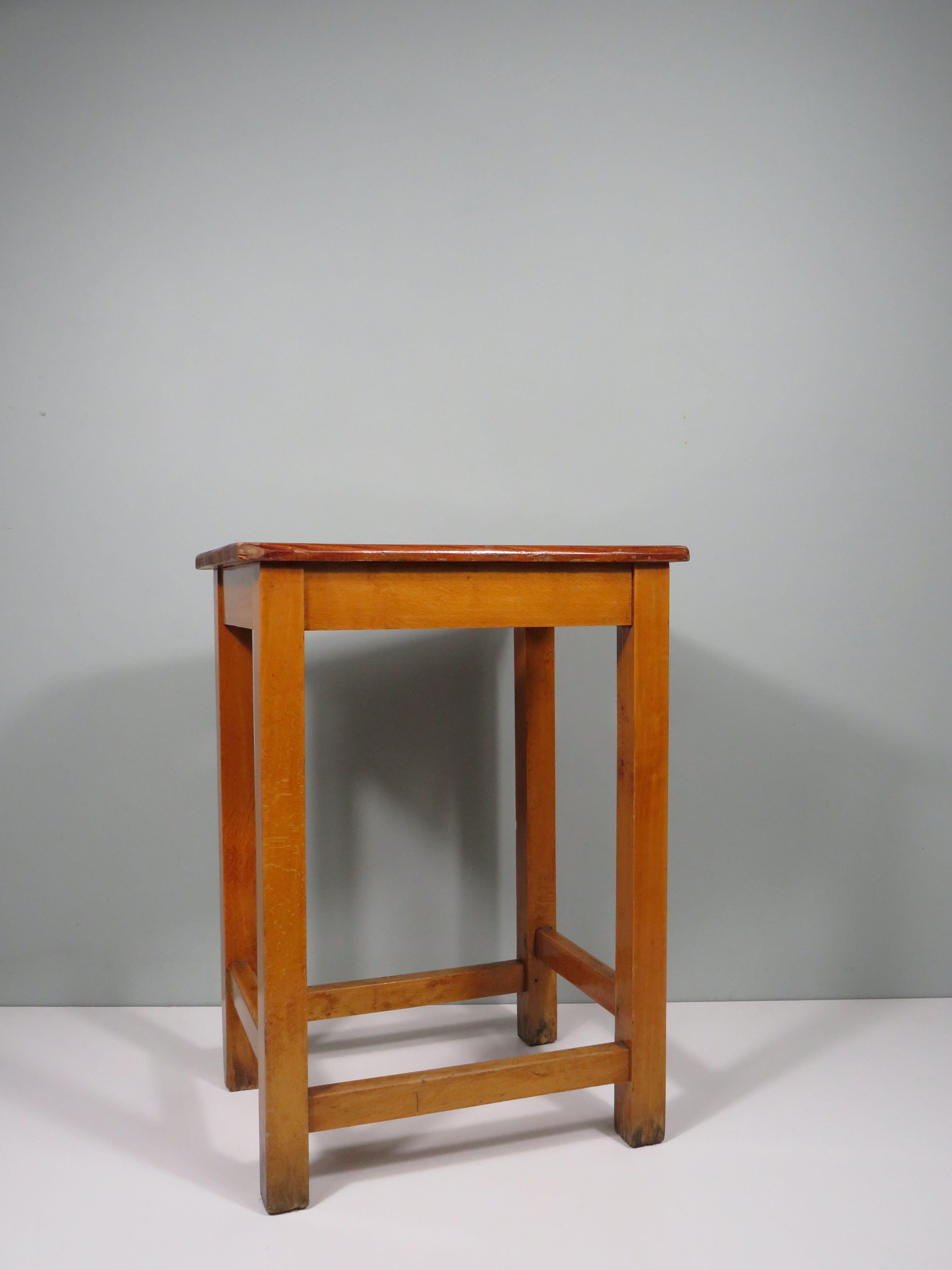 Questo robusto sgabello in pino, utilizzato in uno studio, trasuda artigianalità e autenticità. La patina calda racconta una storia, mentre la maniglia offre una maggiore facilità d'uso. Un mobile ideale per chi ama gli interni creativi o il vintage.