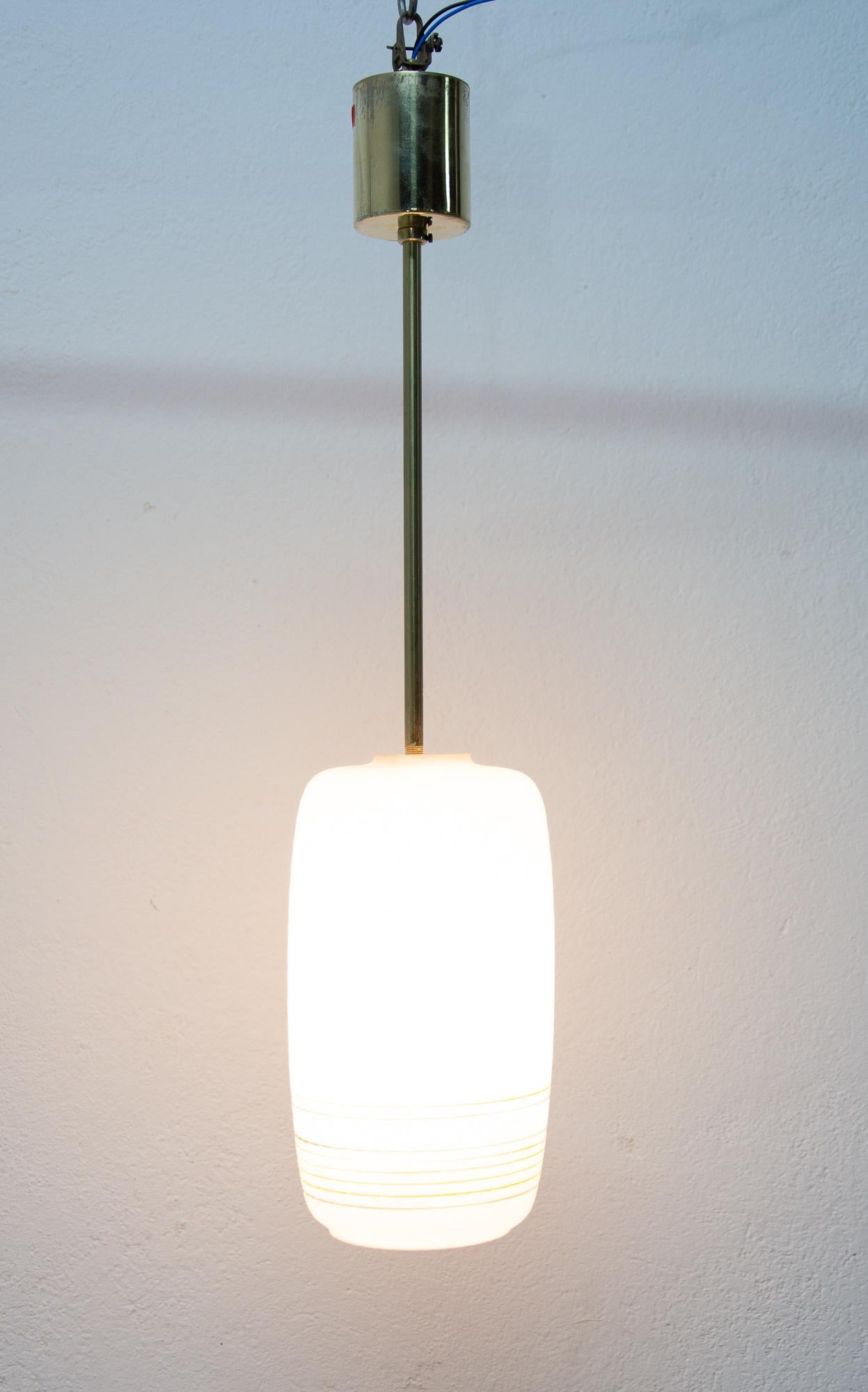 Pendant / Fixture in milk glass. Brass rod. New wiring, cleaned, in very good vintage condition condition.